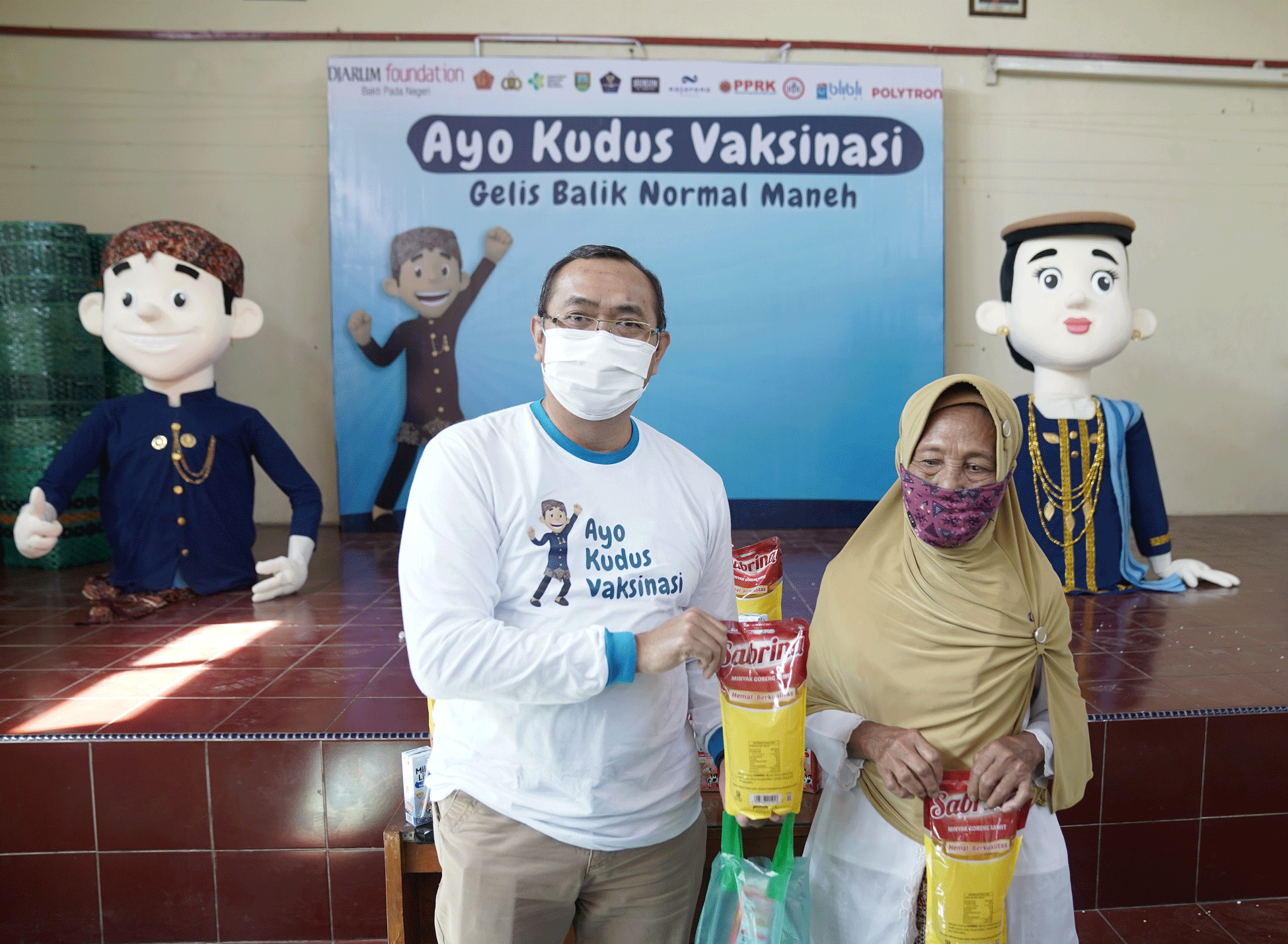 Pembagian minyak goreng menjadi daya pikat bagi lansia ikut vaksinasi covid-19 di di Desa Bulungcangkring, Jekulo, Kudus, Kamis (24/3). 