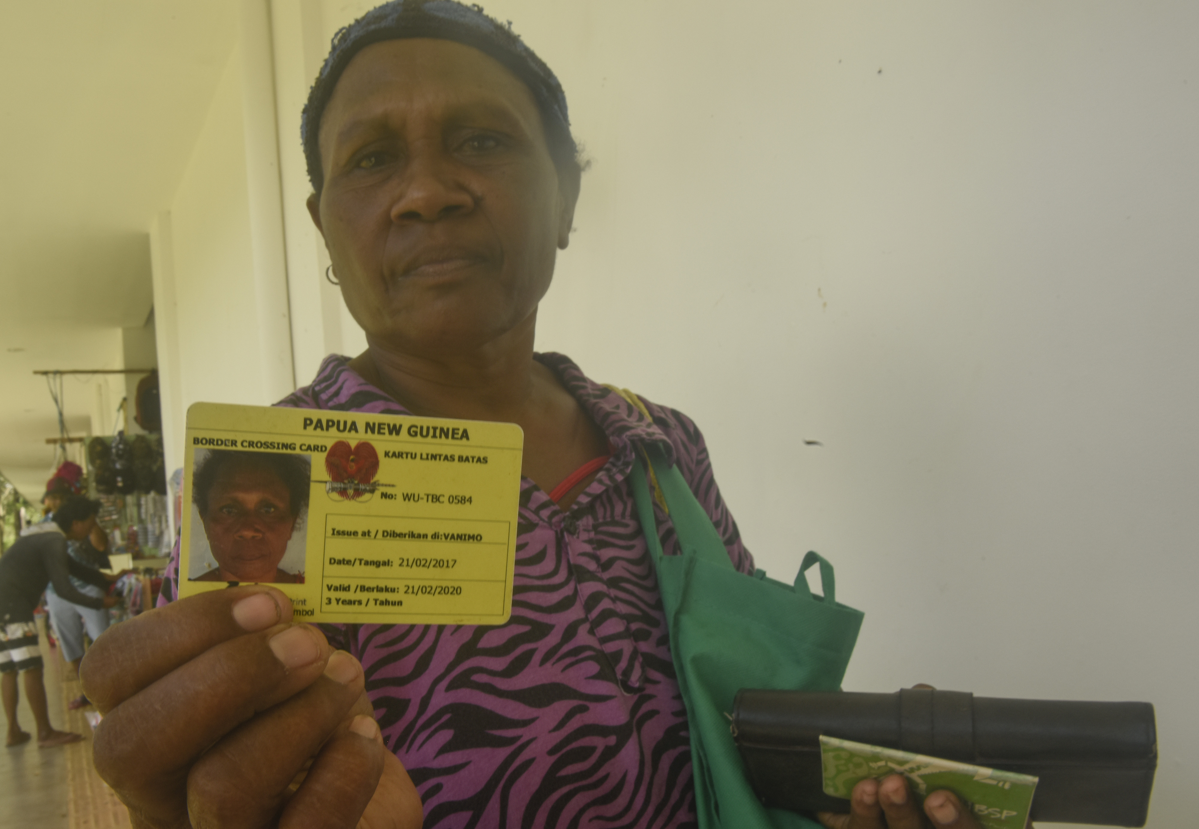 Warga Papua Nugini Merry James memperlihatkan kartu lintas batas ketika berbelanja di Pasar Skouw, Jayapura, Papua, Kamis (14/10/2021).