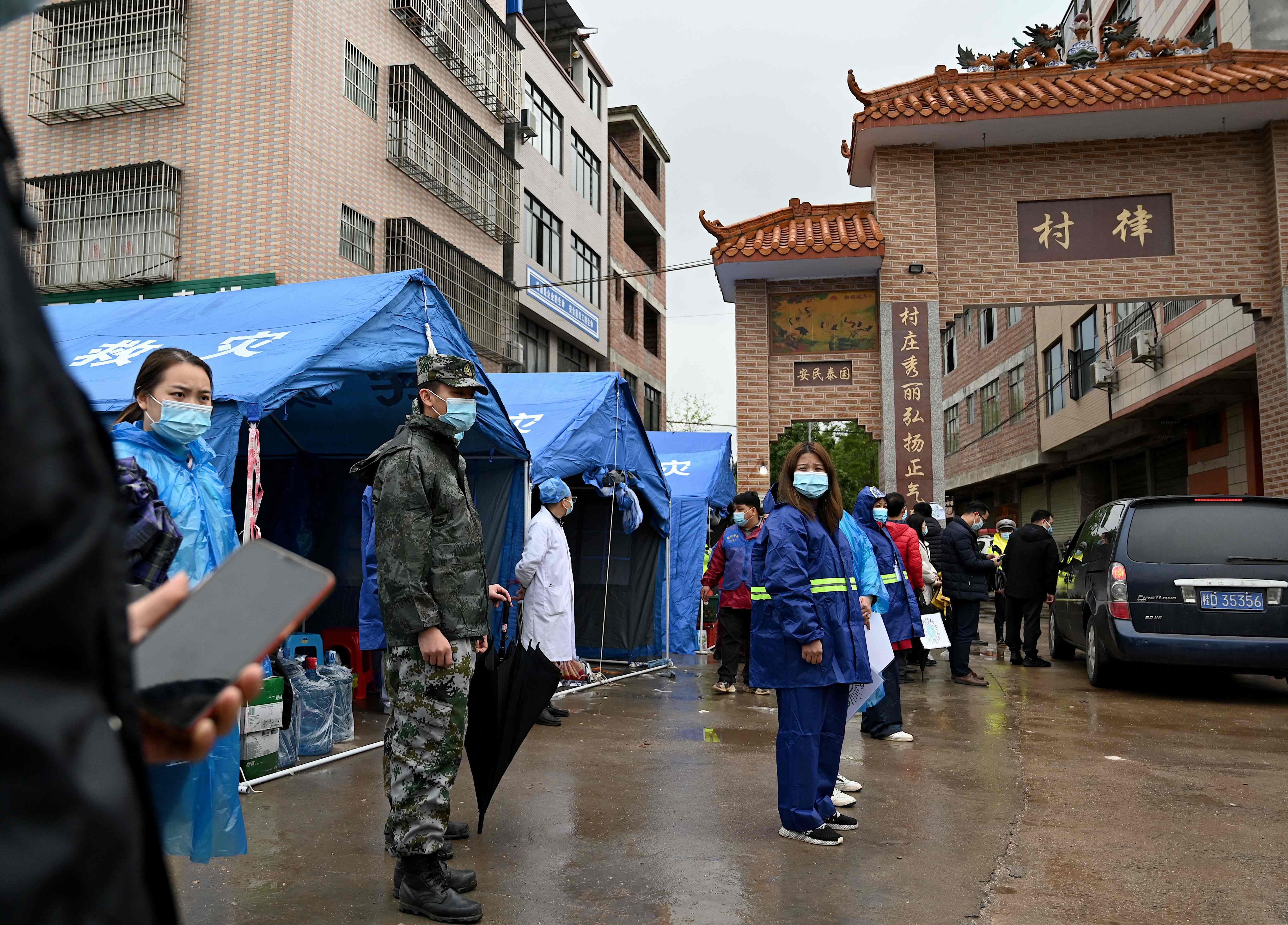 Petugas keamanan berjaga di sekitar pintu masuk desa menuju lokasi kecelakaan pesawat China Eastern.