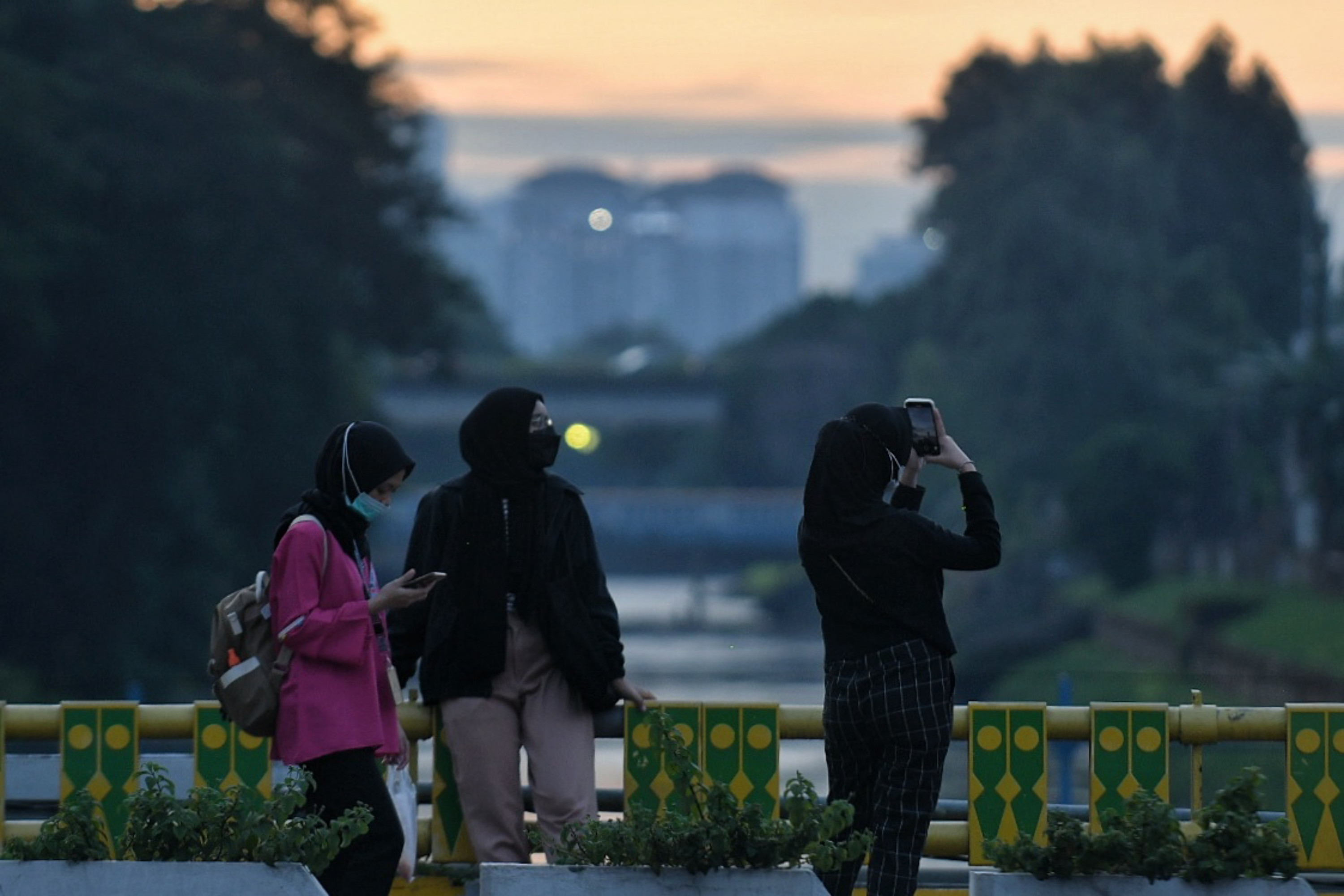 Pekerja berjalan di kawasan jalan Jenderal Sudirman, Jakarta.