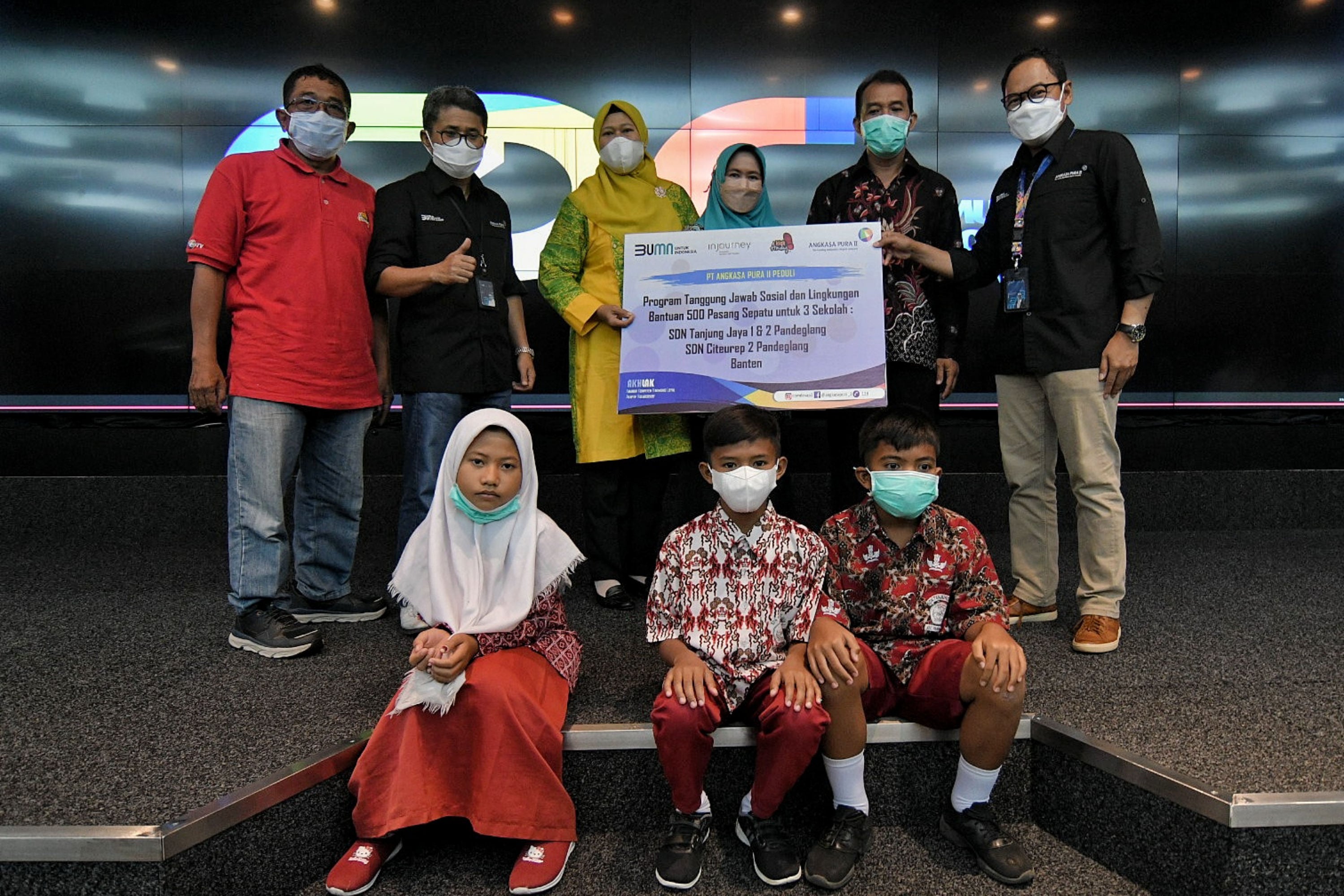 Direktur keuangan Angkasa Pura II Wiweko Probojakti (kanan) menyerahkan bantuan sepatu kerja sama Yayasan Kick Andy Foundation, Rabu (23/3).