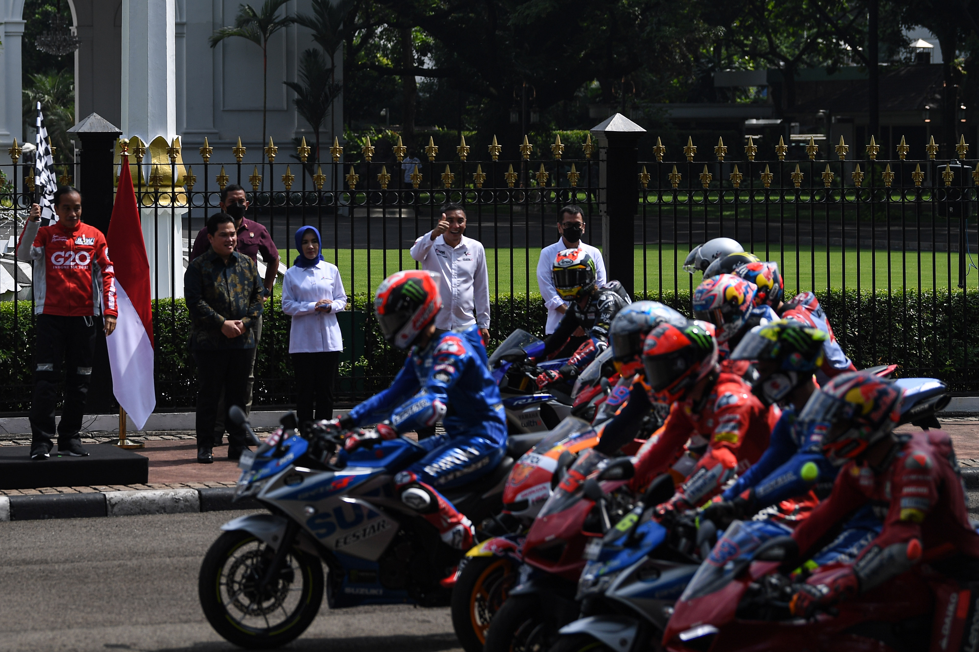 Menteri BUMN Erick Thohir (dua kiri) mendampingi Presiden Jokowi saat melepas pembalap MotoGP melakukan pawai, Rabu (16/3).