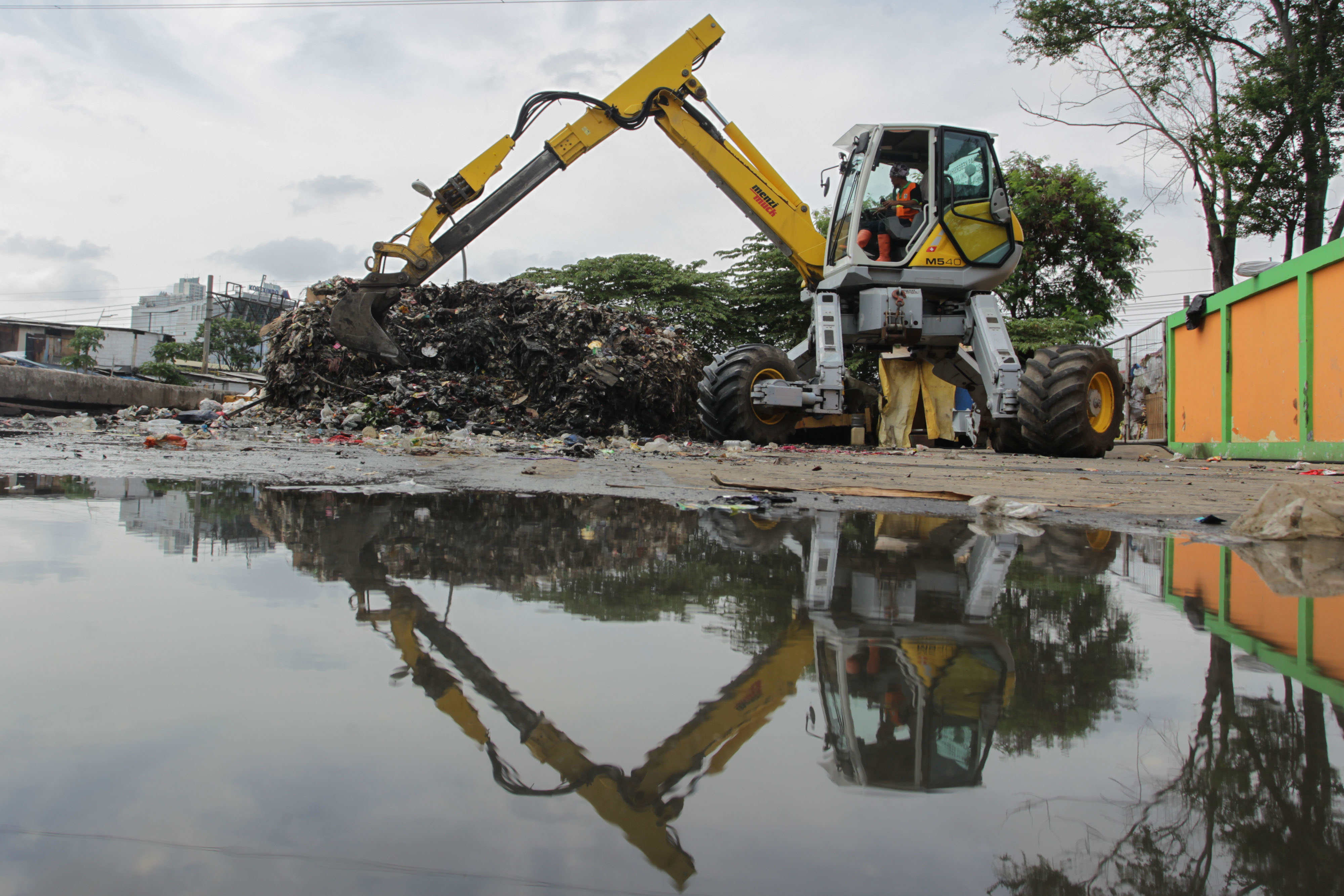 Alat berat sedang memindahkan sampah