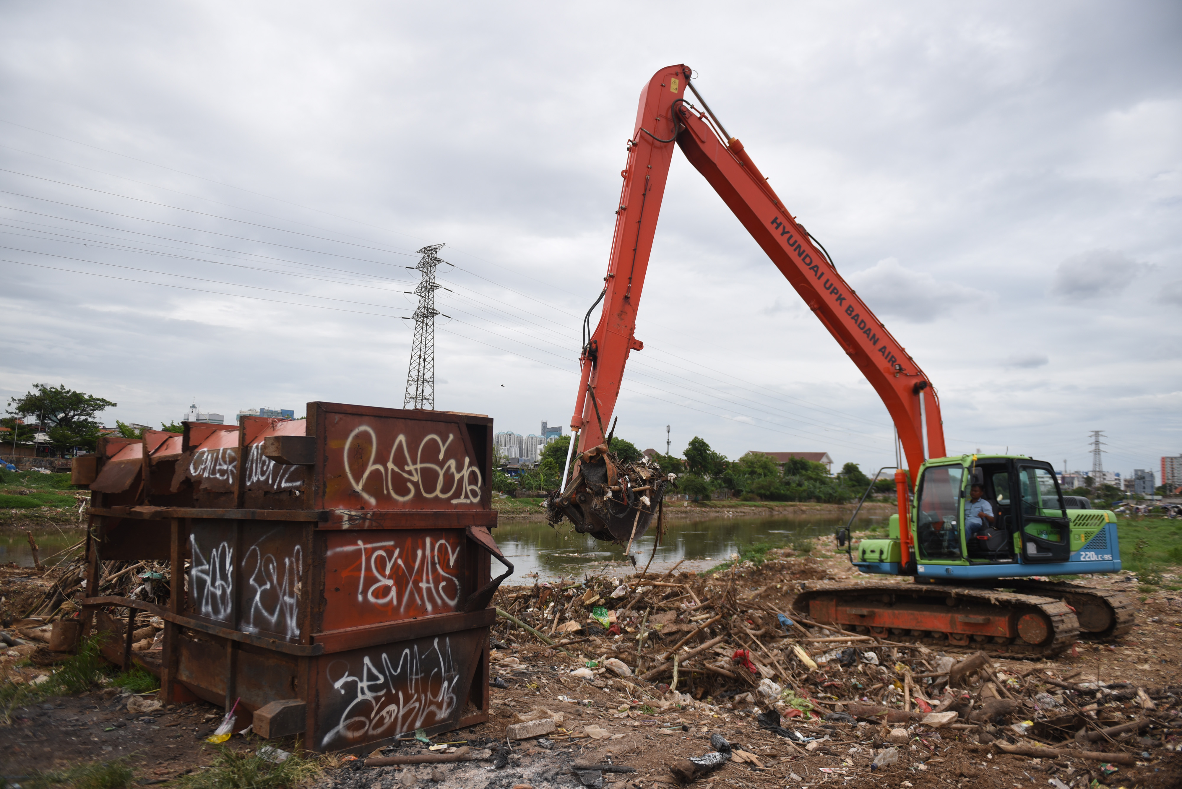 Ilustrasi: Excavator sedang mengeruk sampah di Kali Ciliwung