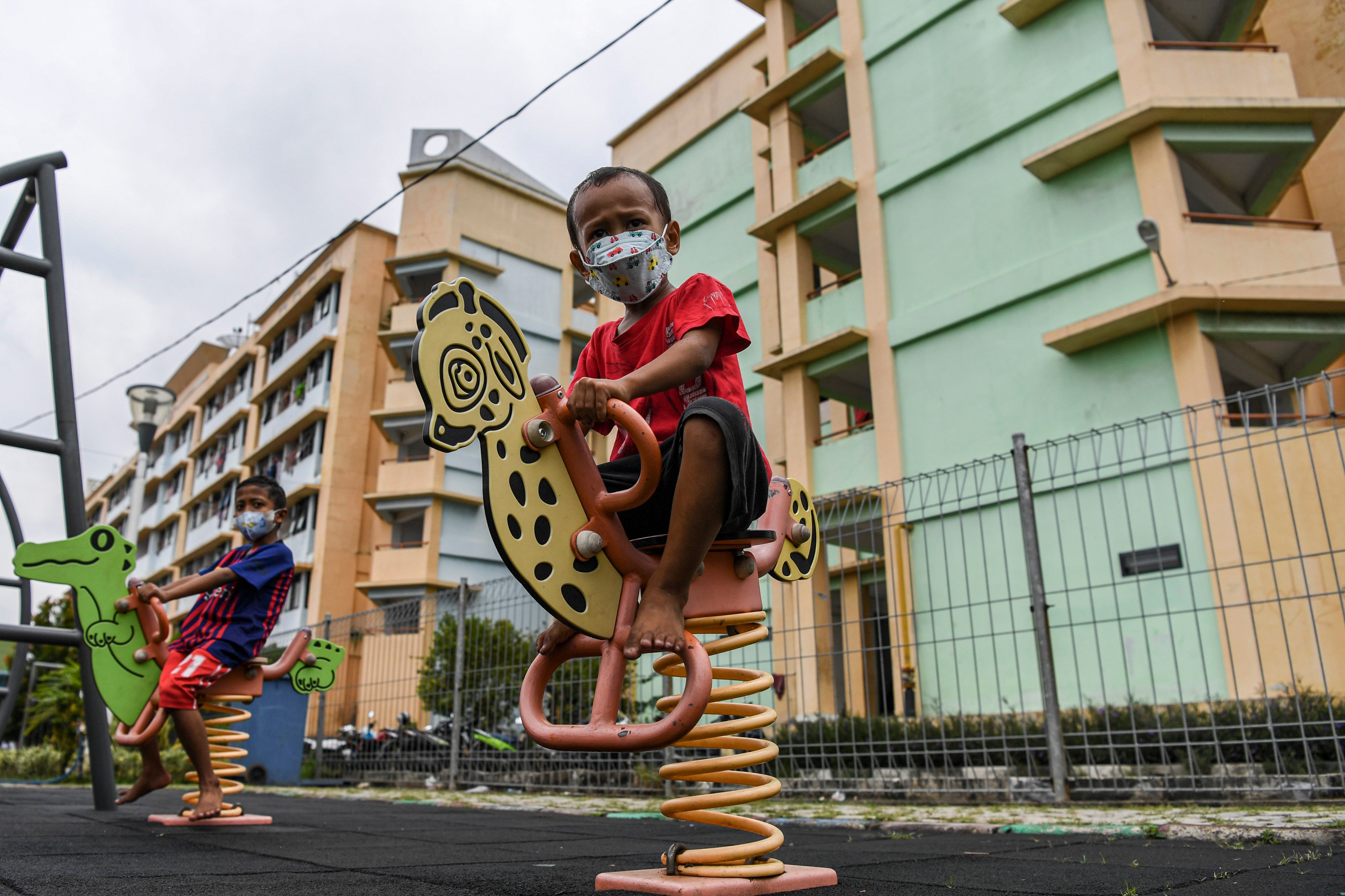 Sejumlah anak di kawasan Rusun Marunda, Jakarta mengenakan masker saat bermain.