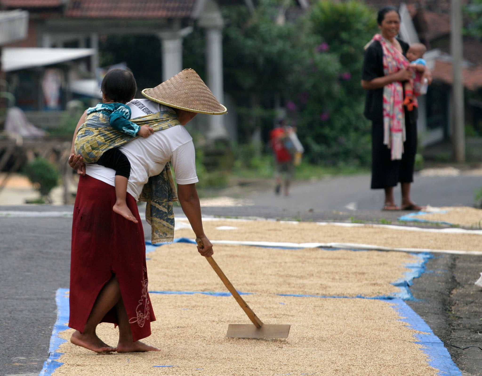 PERAN GANDA: Perempuan di pedesaan terpaksa nelakukan peran ganda bekerja membantu ekonomi keluarga sambil tetap mengasuh anaknya. 