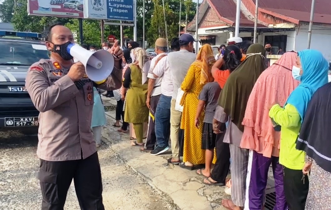 Kapolres Bungo AKB Guntur Saputro membantu mengawasi protokol kesehatan di tengah serbuan warga yang antre hendak membeli minyak goreng.