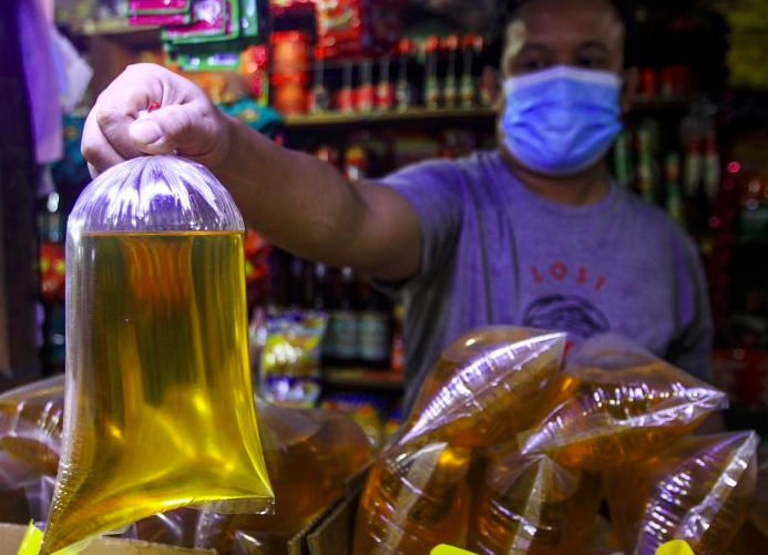 Pedagang menunjukkan minyak goreng curah