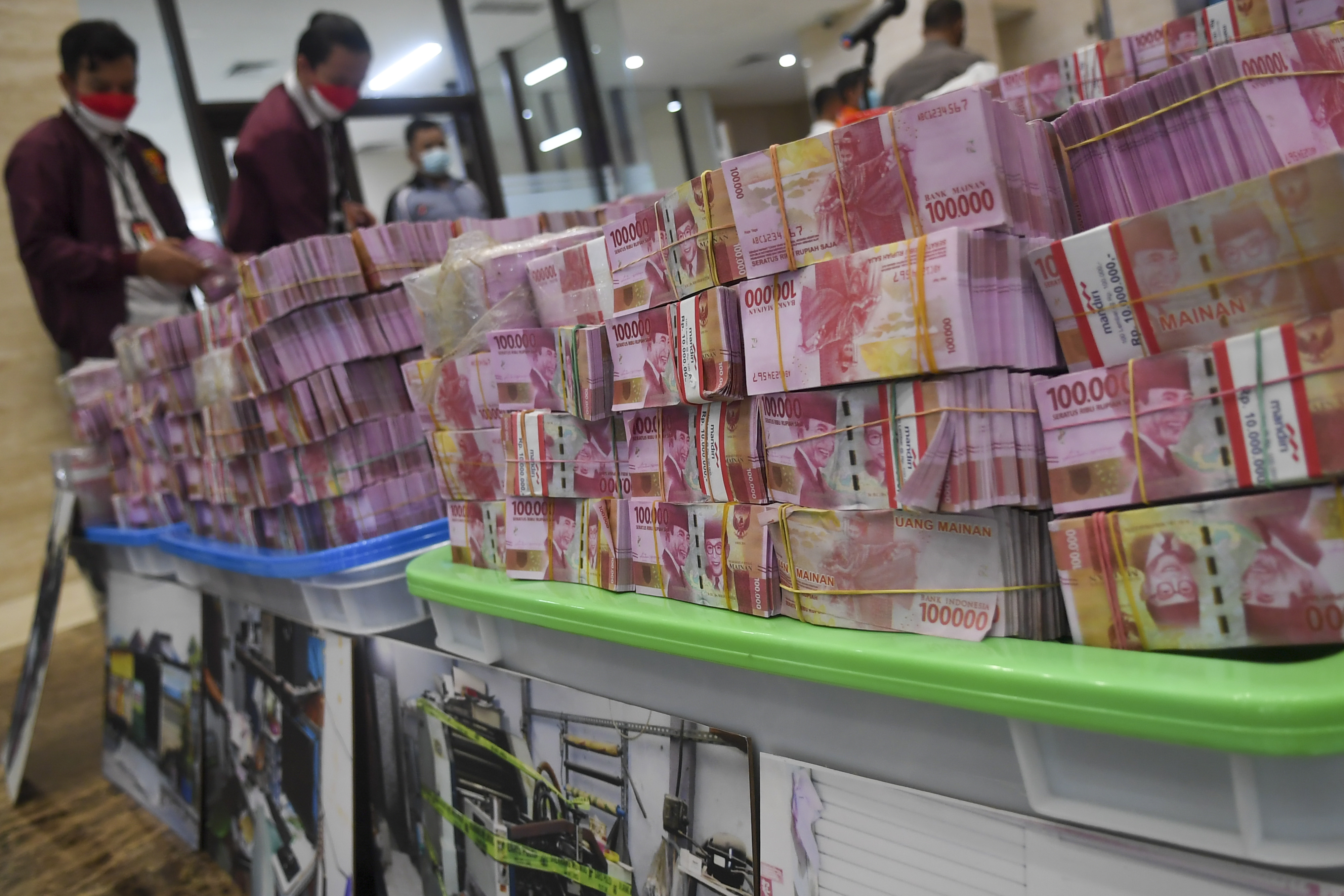 Petugas kepolisian menata barang bukti mata uang rupiah palsu saat rilis pengungkapan kejahatan mata uang palsu di Bareskrim Mabes Polri.