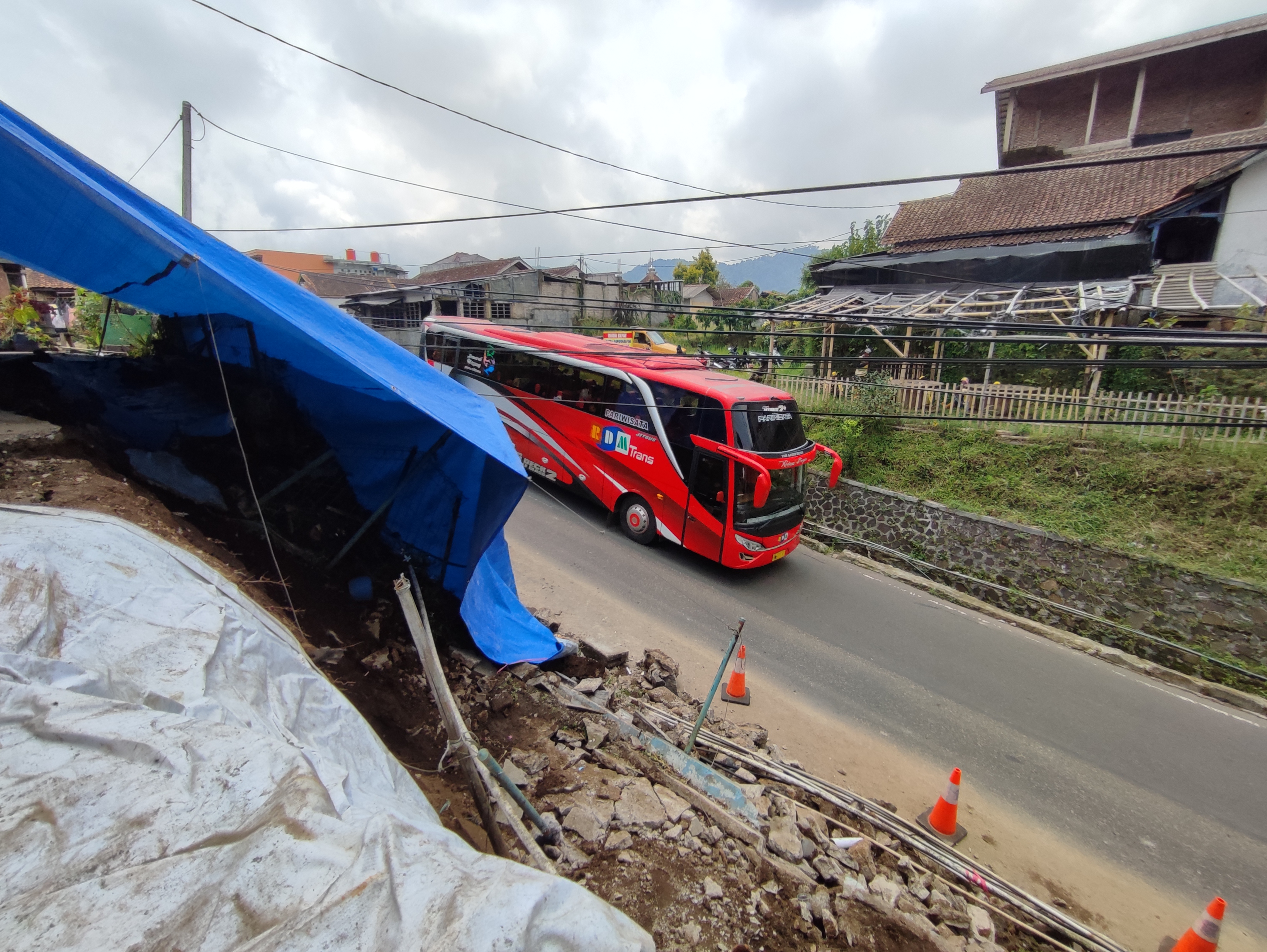 Kendaraan melintasi lokasi longsor di Desa Cikole Jalan Tangkuban Parahu Lembang, Kabupaten Bandung Barat, Sabtu (19/3).