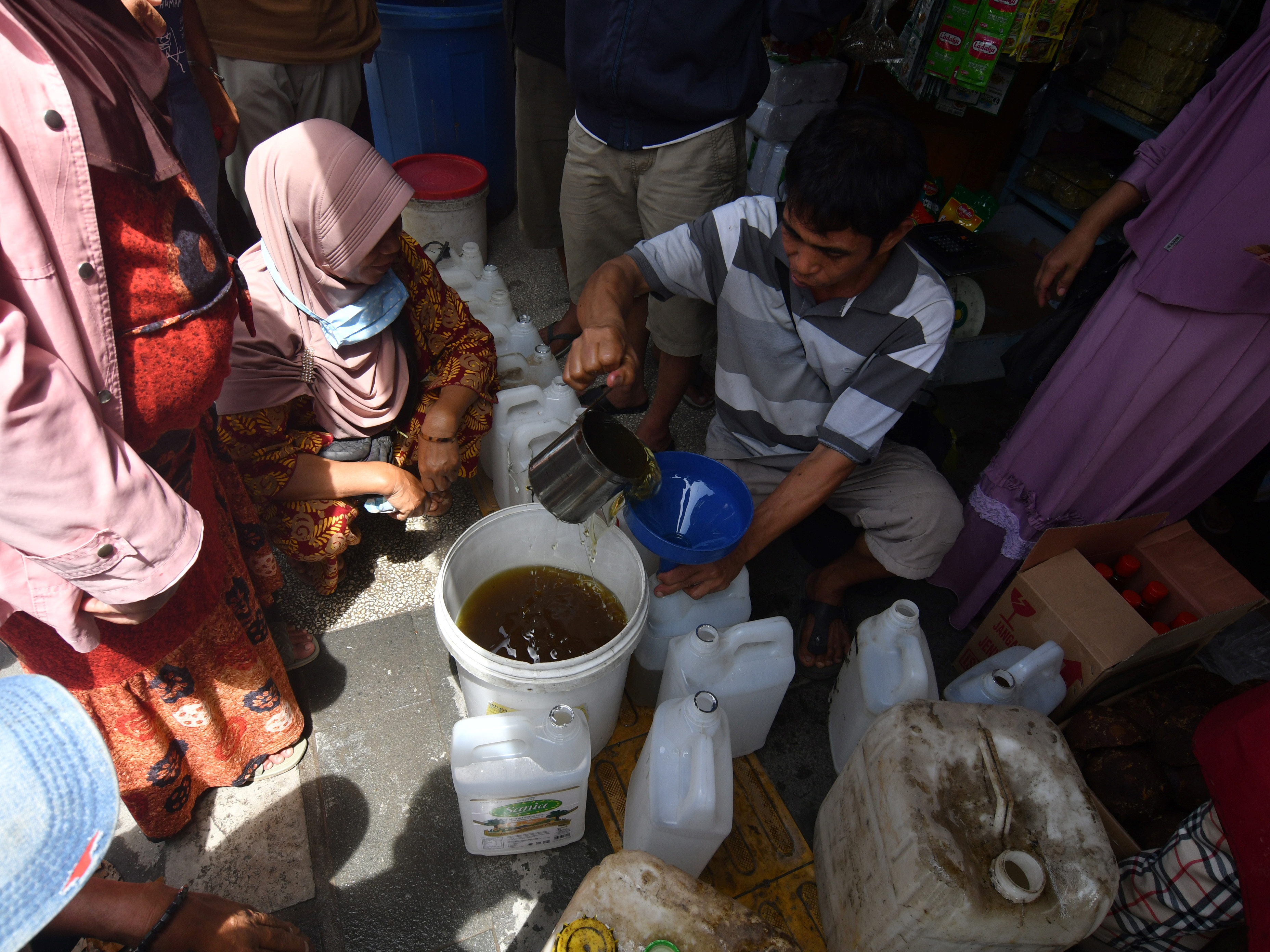 Pedagang pengecer melayani pembelian minyak goreng curah di Pasar Masomba, Palu, Sulawesi Tengah, Jumat (18/3/2022). 