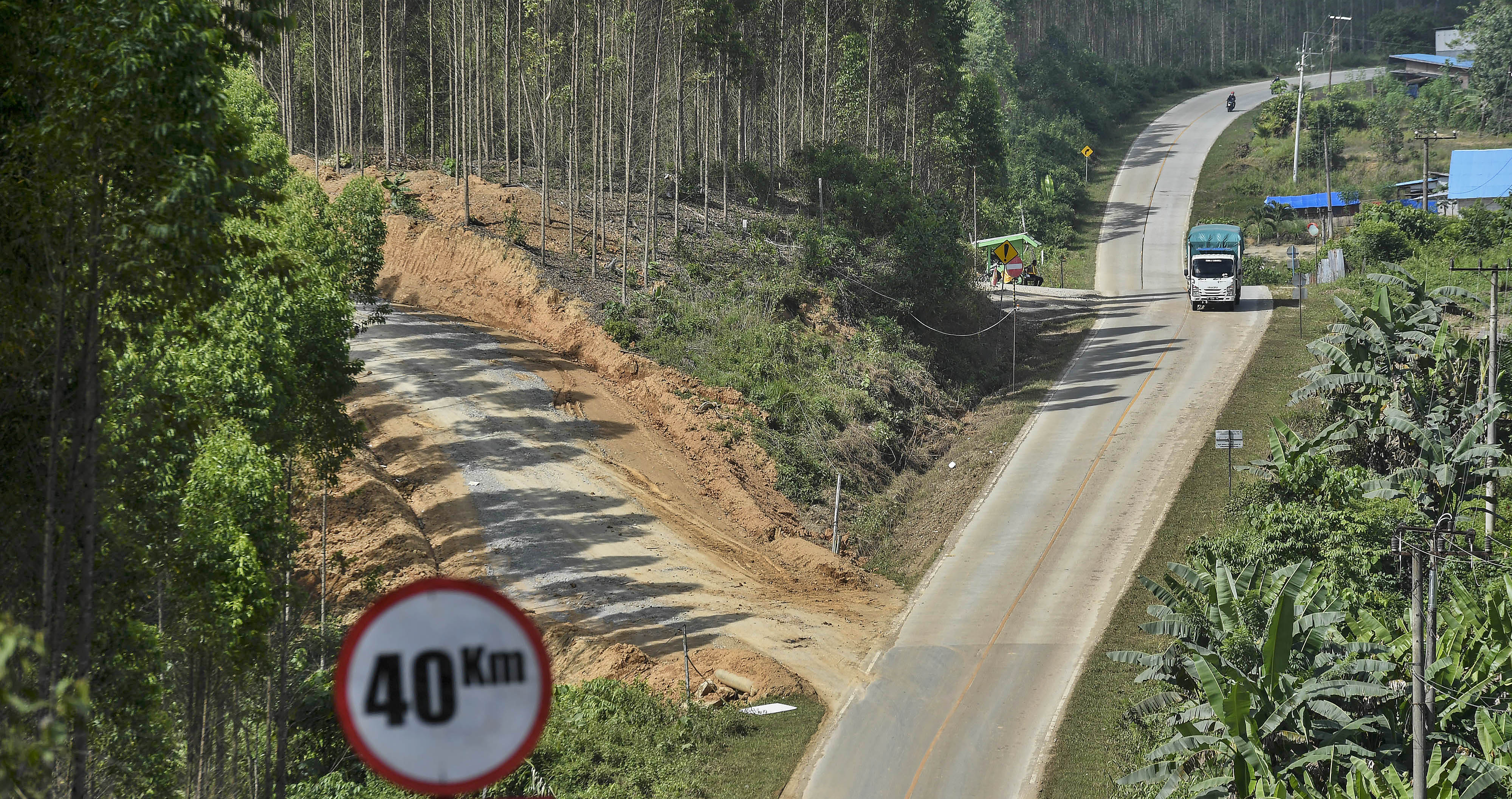 Truk melintas di jalan raya menuju Kawasan Inti IKN Nusantara di Kecamatan Sepaku, Penajam Paser Utara, Kaltim, Selasa (15/3/2022).