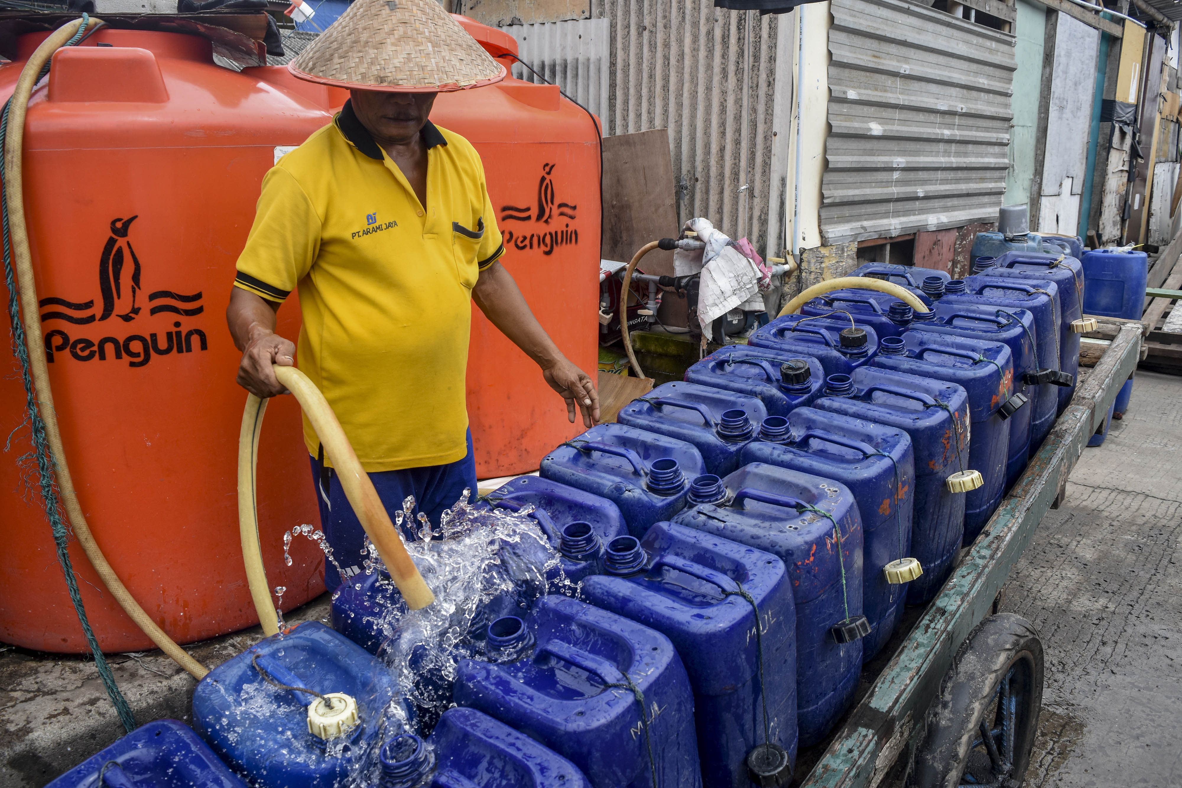 Pedagang mengisi air bersih ke dalam jerigen di Muara Angke, Jakarta.