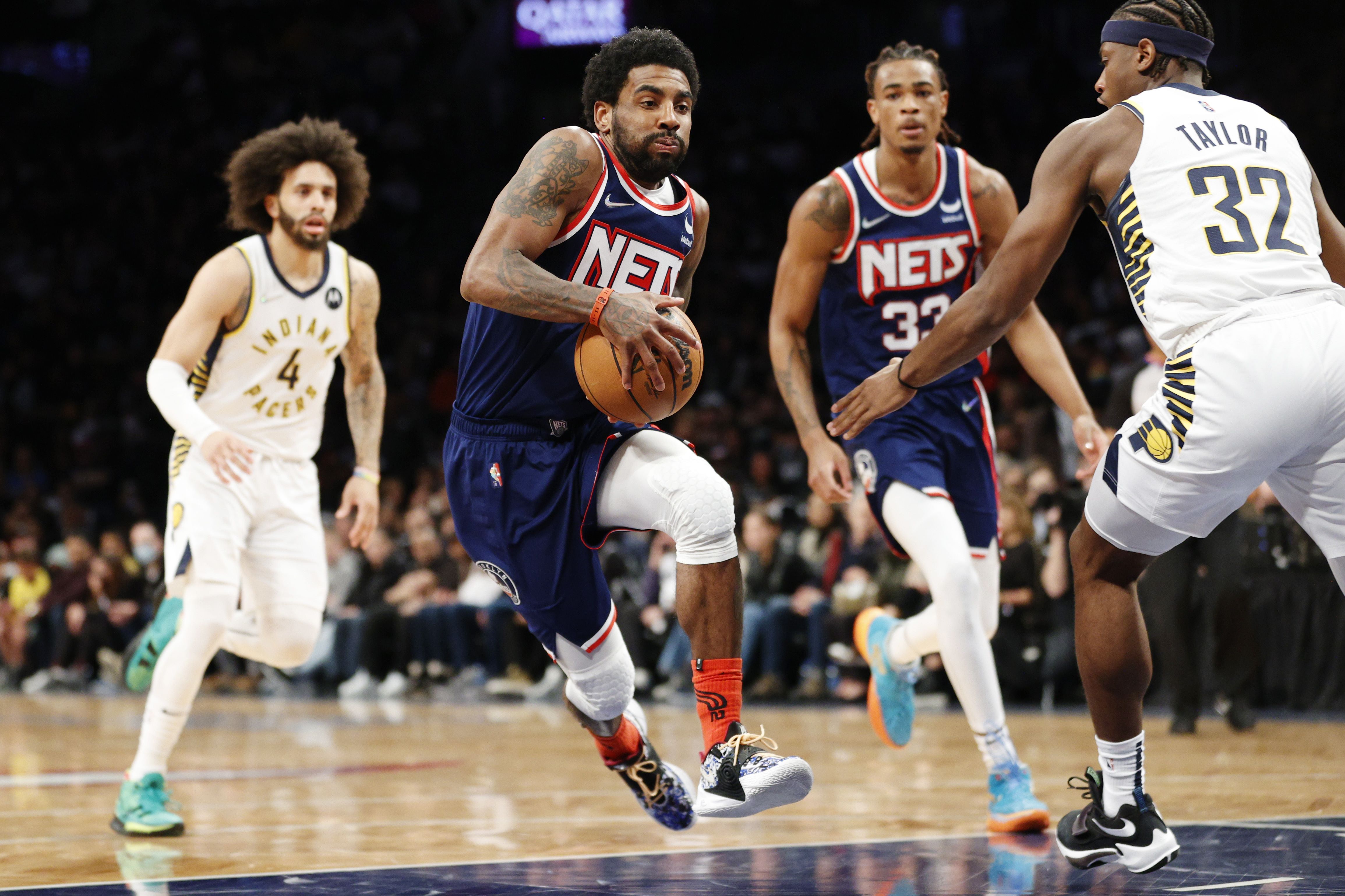 Pemain Brooklyn Nets, Kyrie Irving (memegang bola), mencoba melewati penjagaan pemain Indiana Pacers (kanan) dari Indiana Pacers.