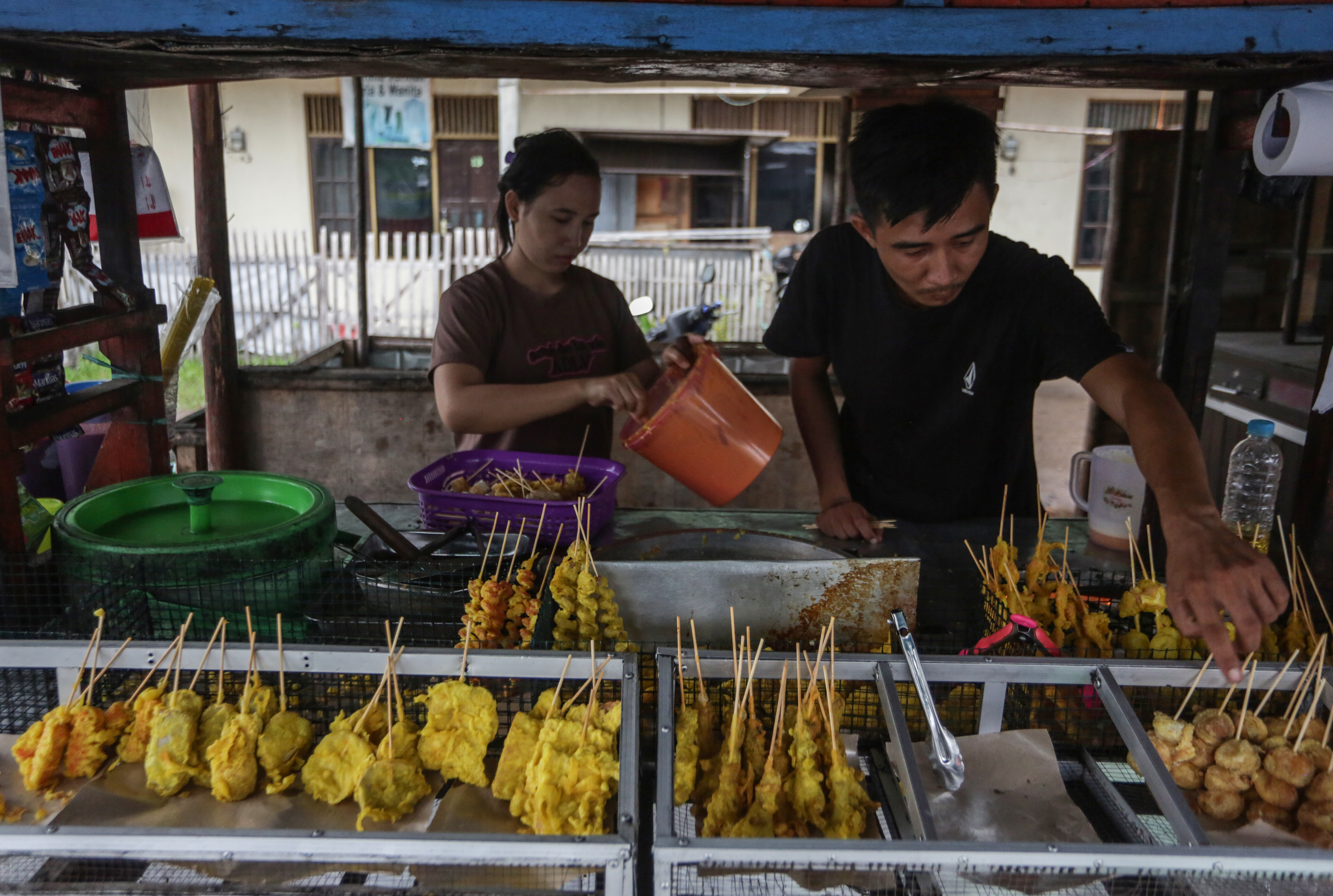 Pedagang menyiapkan makanan gorengan pada lapak dagangannya di Jalan Sisingamangaraja, Palangkaraya, Kalimantan Tengah.