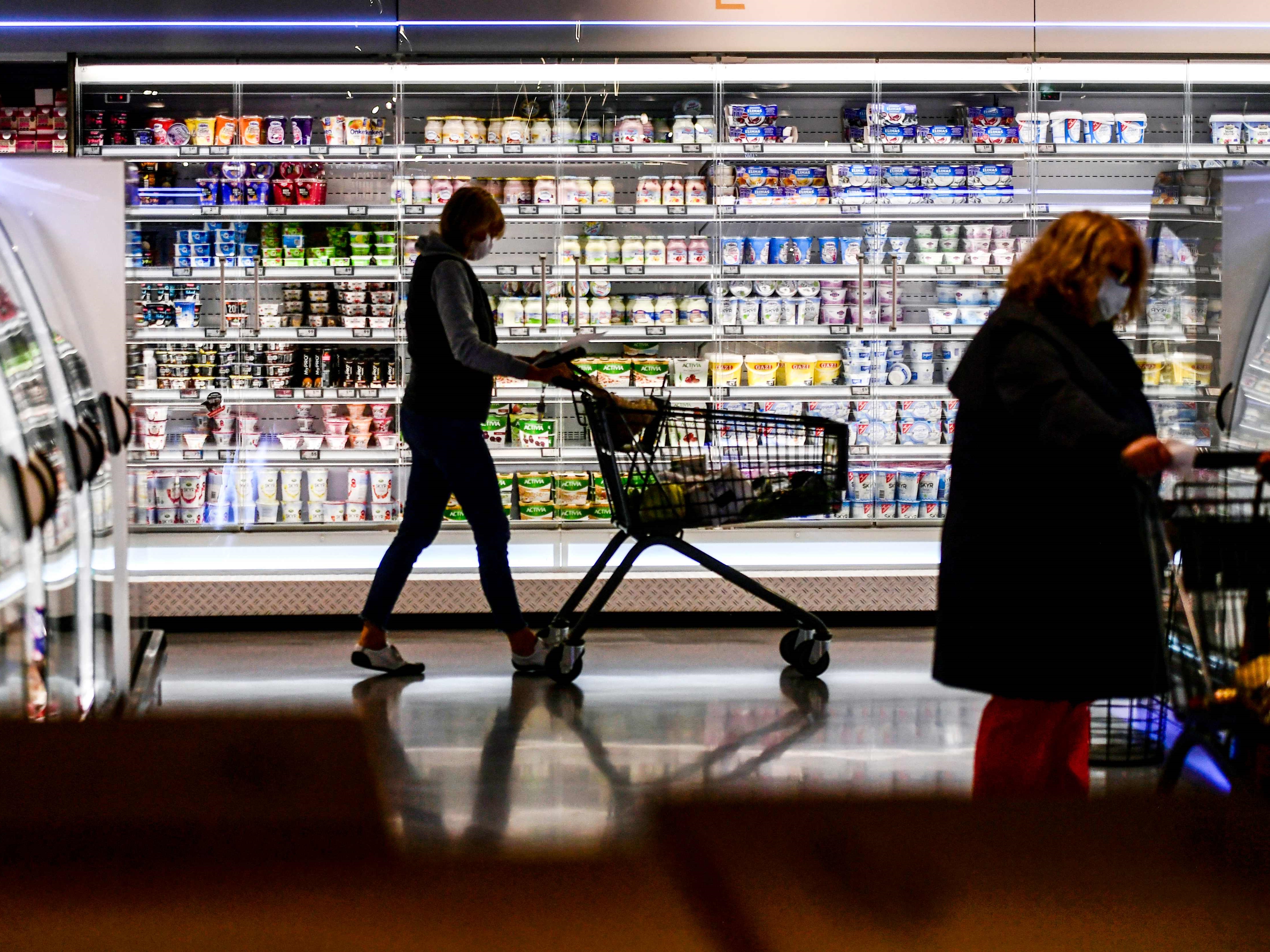 Konsumen mendorong kereta belanja melewati rak selama pembelian di supermarket di Duesseldorf, Jerman barat, pada 29 April 2020. 