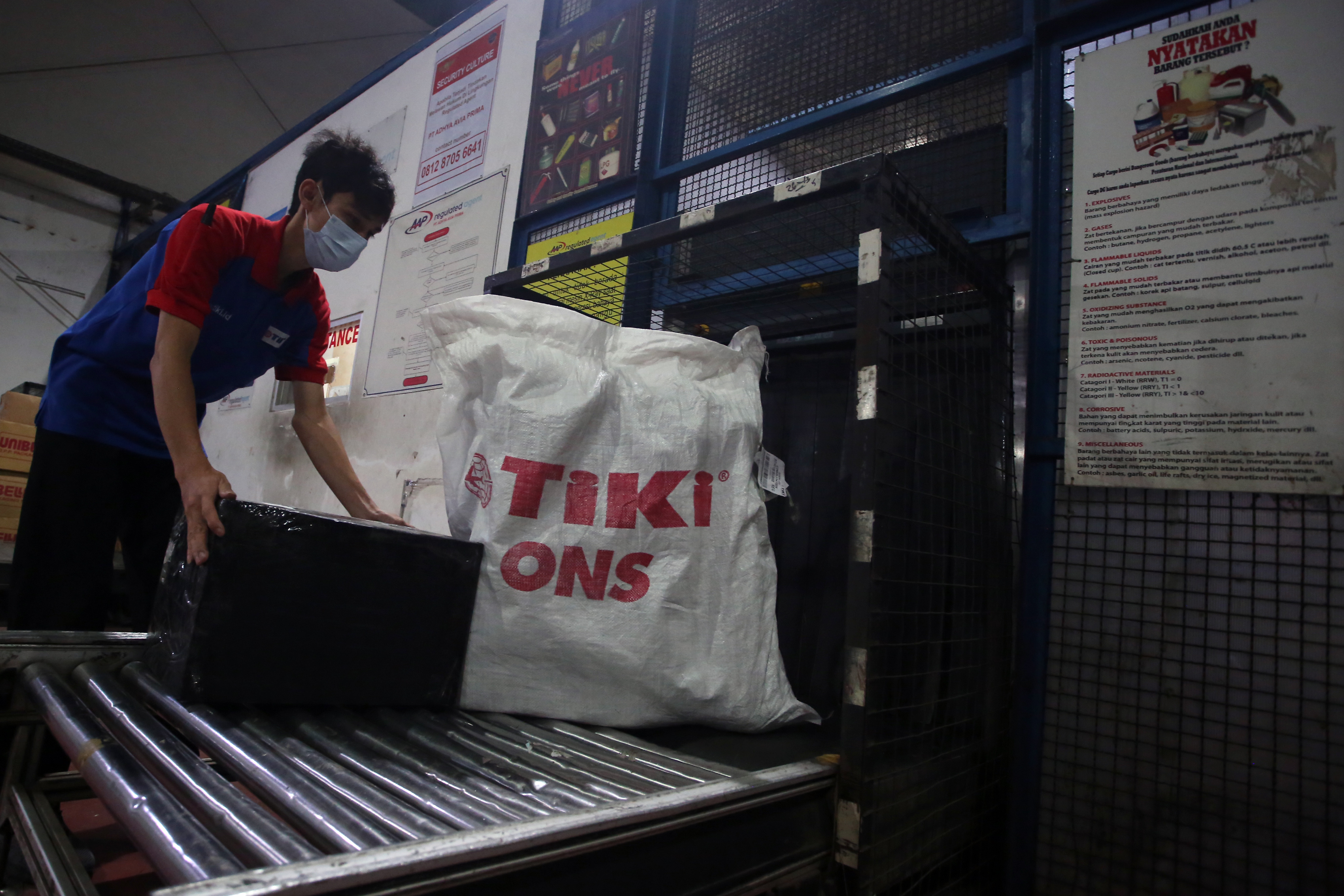 Pekerja memeriksa paket barang kiriman sebelum diberangkatkan dengan menggunakan pesawat di Gudang transit TIKI.
