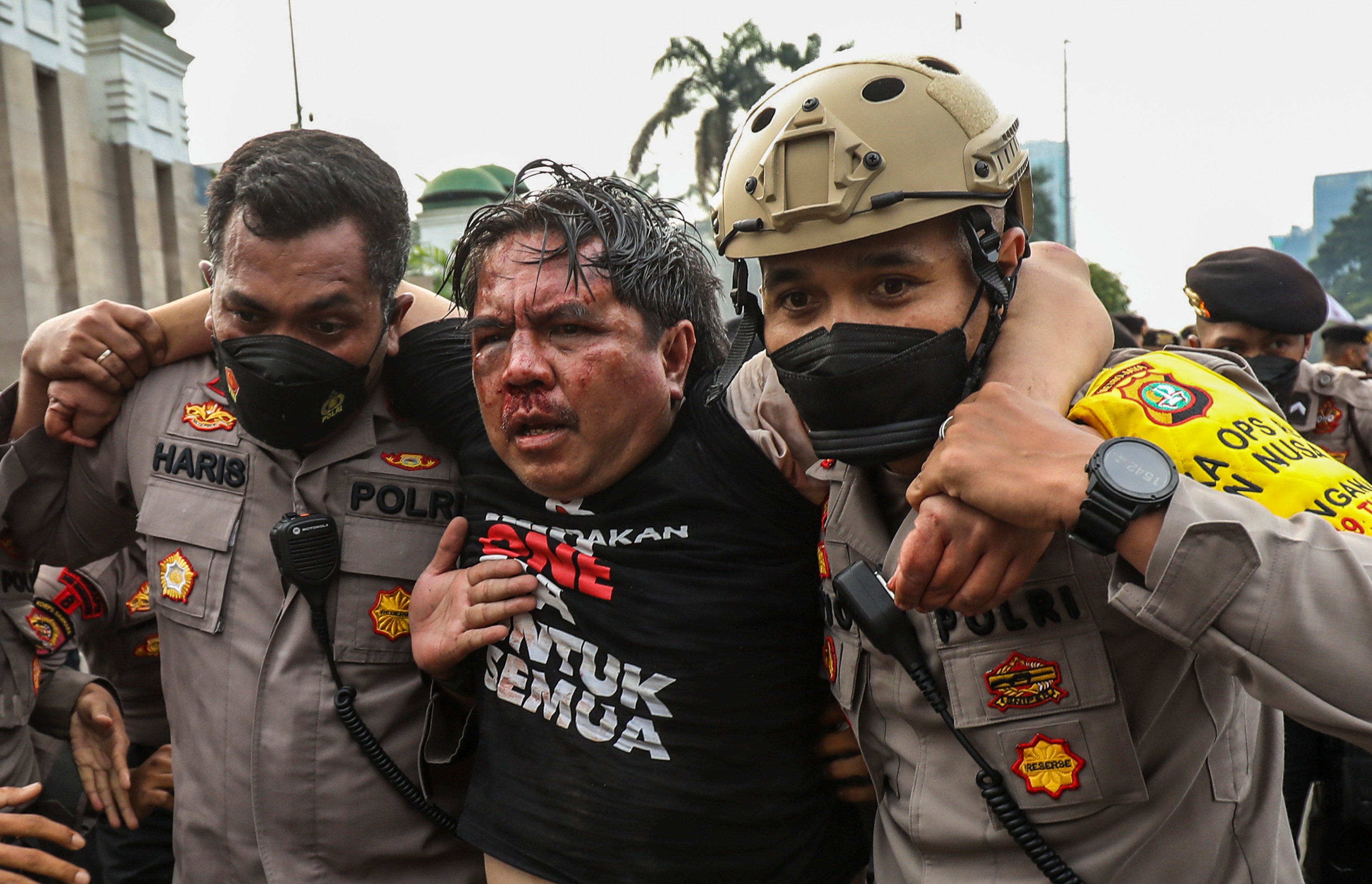 Ade Armando saat dibawa petugas untuk keluar dari barisan demonstrasi setelah dikeroyok