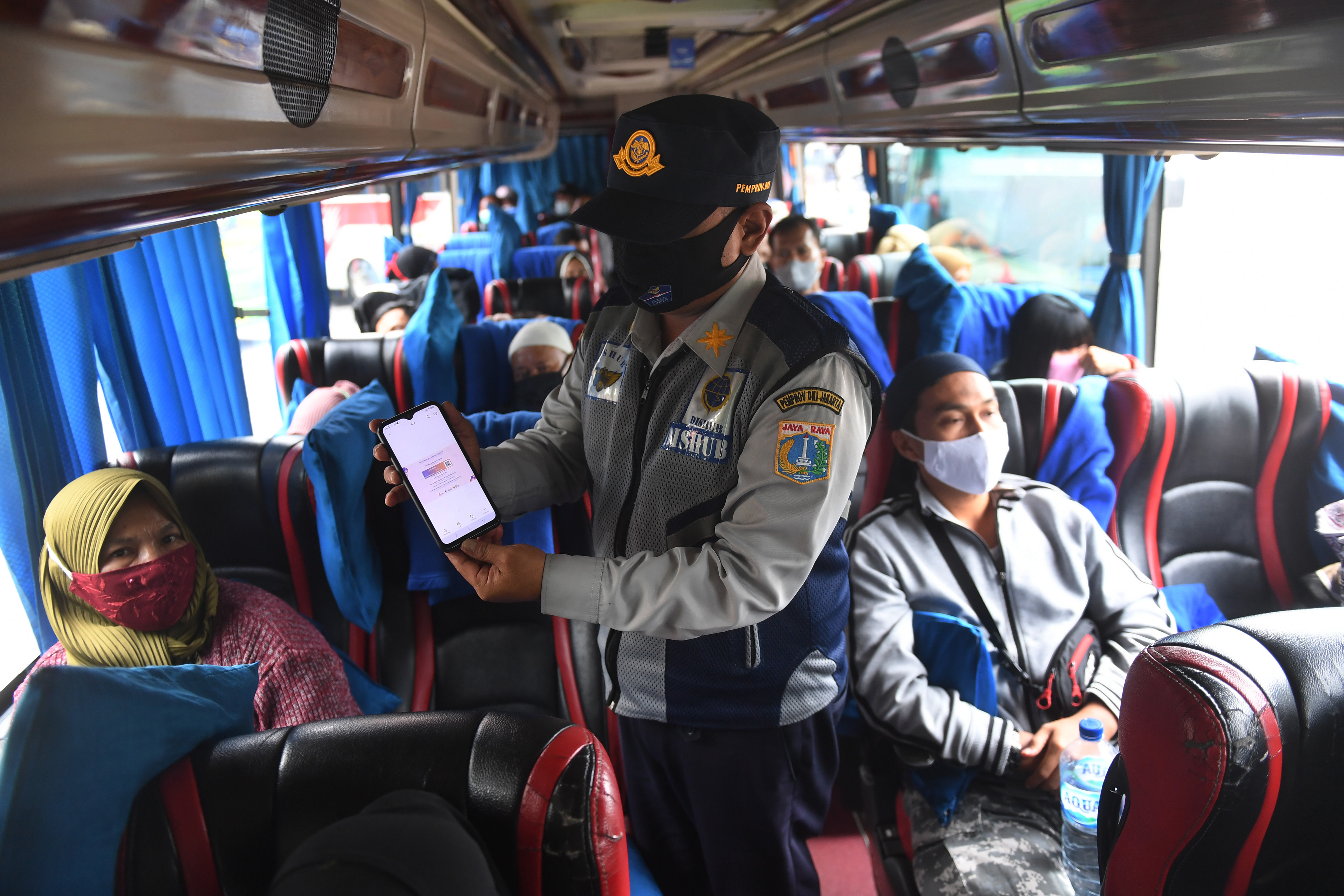 Petugas memeriksa syarat perjalanan pemudik yang menggunakan bus AKAP di Terminal kampung Rambutan, Jakarta