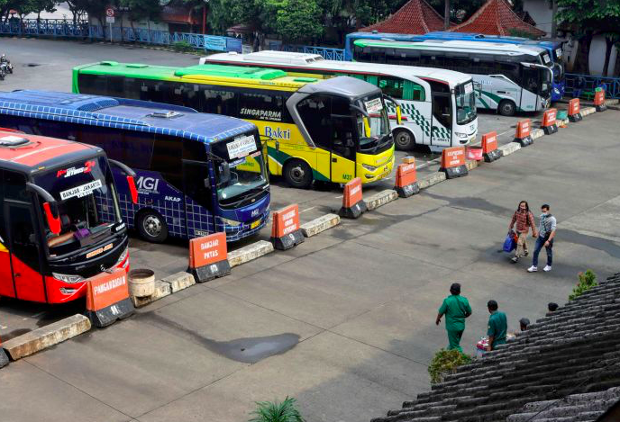 Calon penumpang berjalan menuju bus di Terminal Kampung Rambutan, Jakarta, Sabtu (27/3/2021).