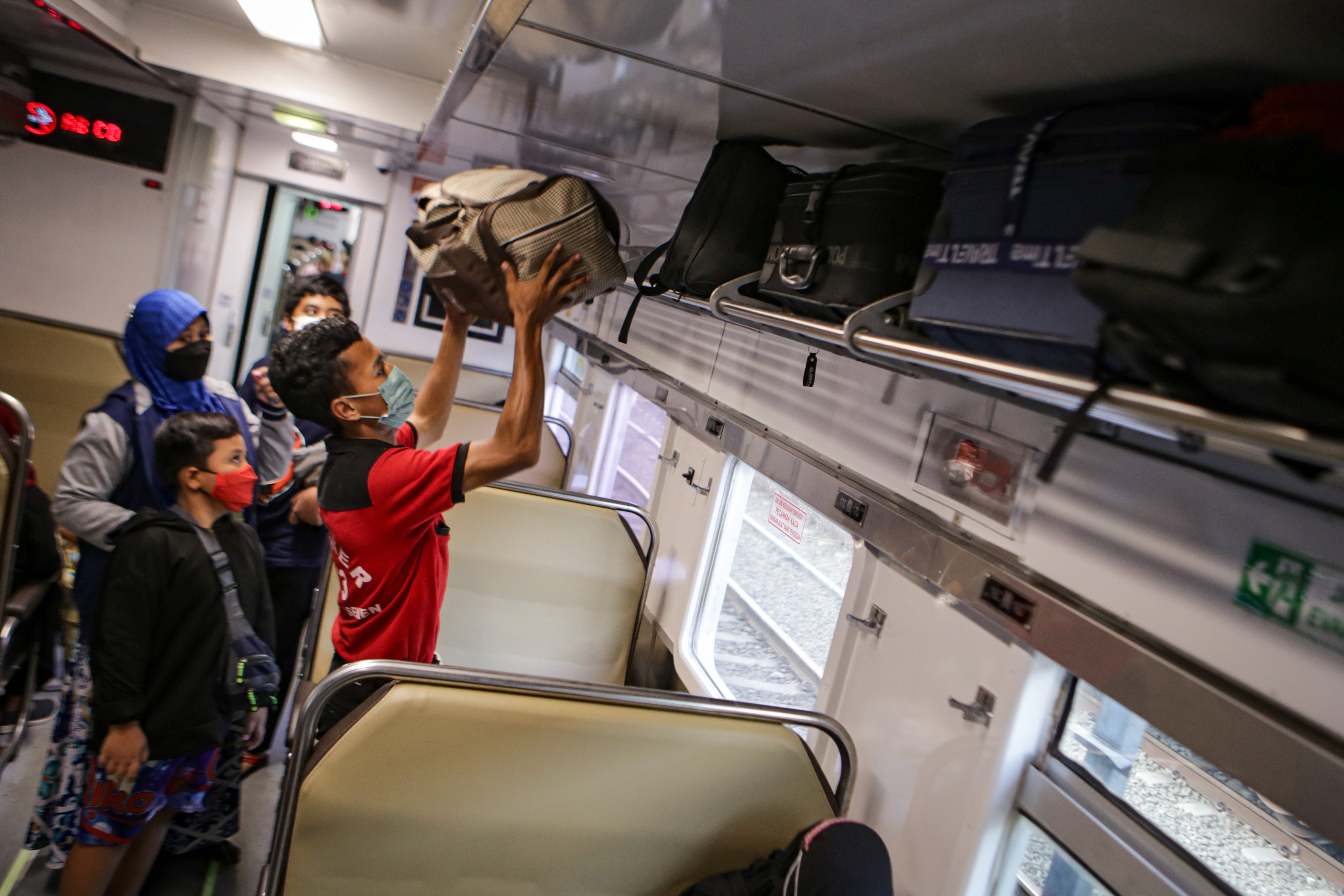 Petugas membantu penumppang KA jarak jauh di Stasiun Pasar Senen, Jakarta