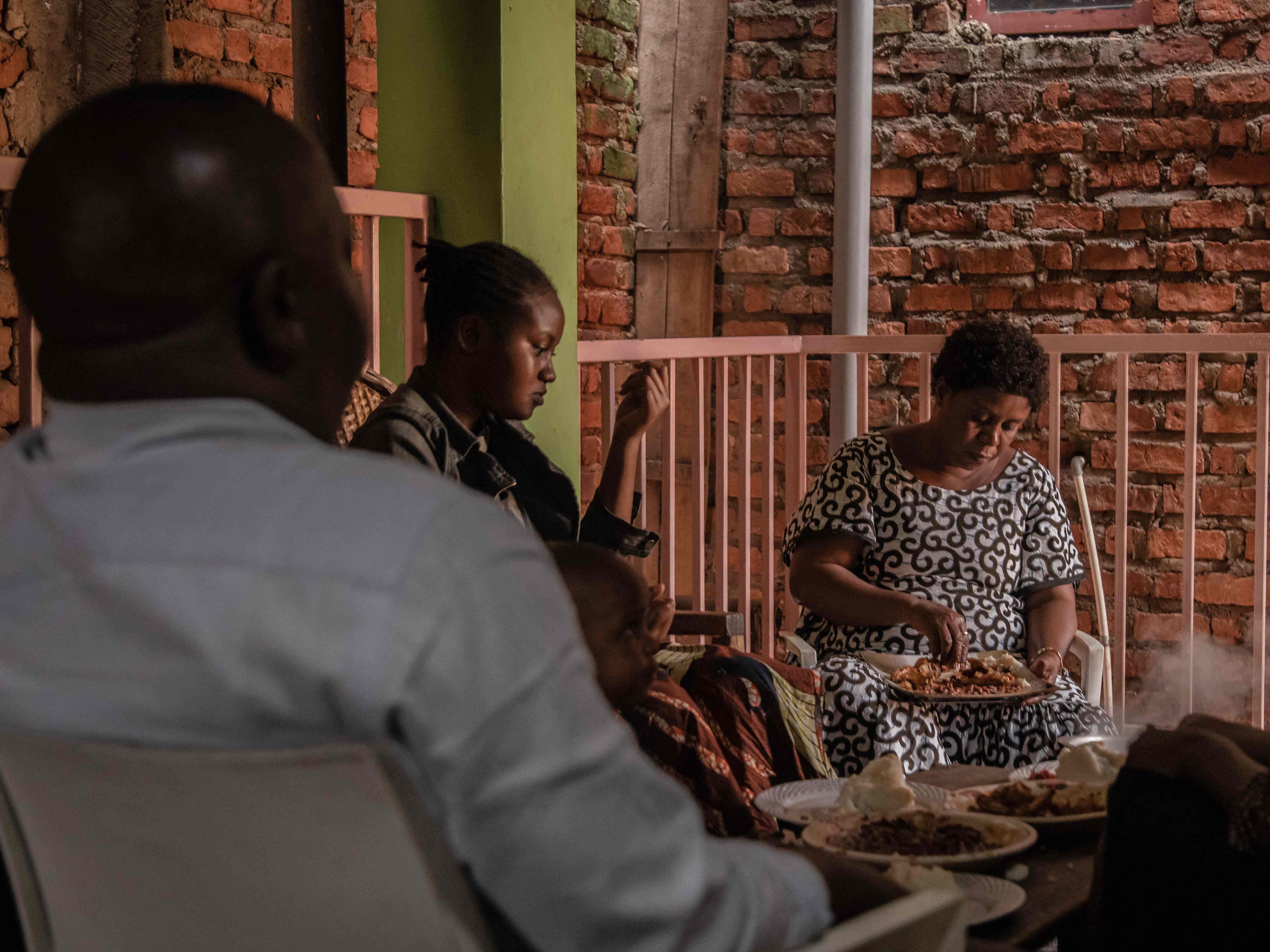 Chirhuza Zagabe (tampak belakang) makan siang di dapur di Bukavu, Republik Demokratik Kongo timur, pada 20 Maret 2022.