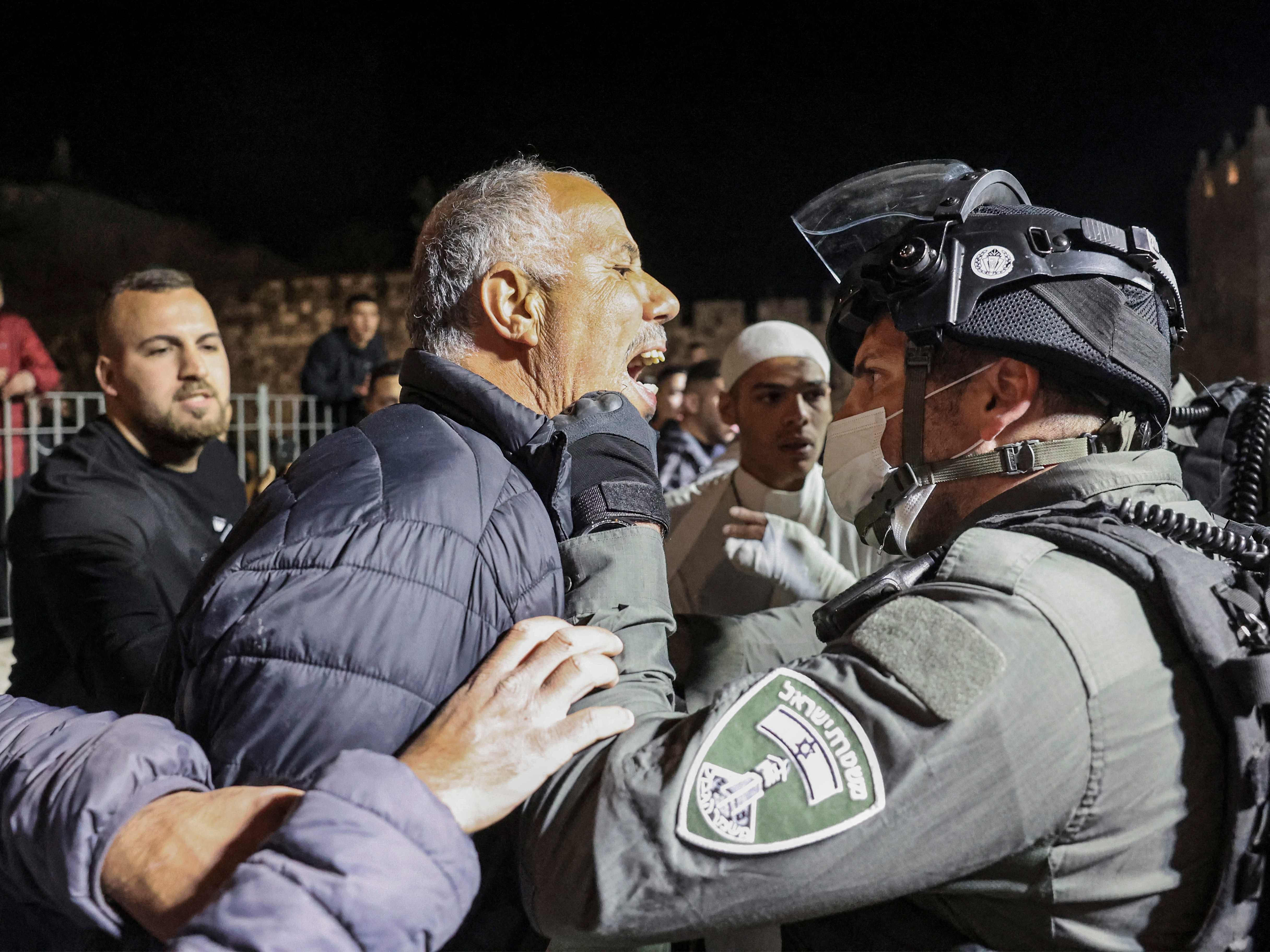 Seorang pria Palestina berdebat dengan penjaga perbatasan Israel selama bentrokan warga di dekat Damaskus kota tua Jerusalem, 3 April 2022.