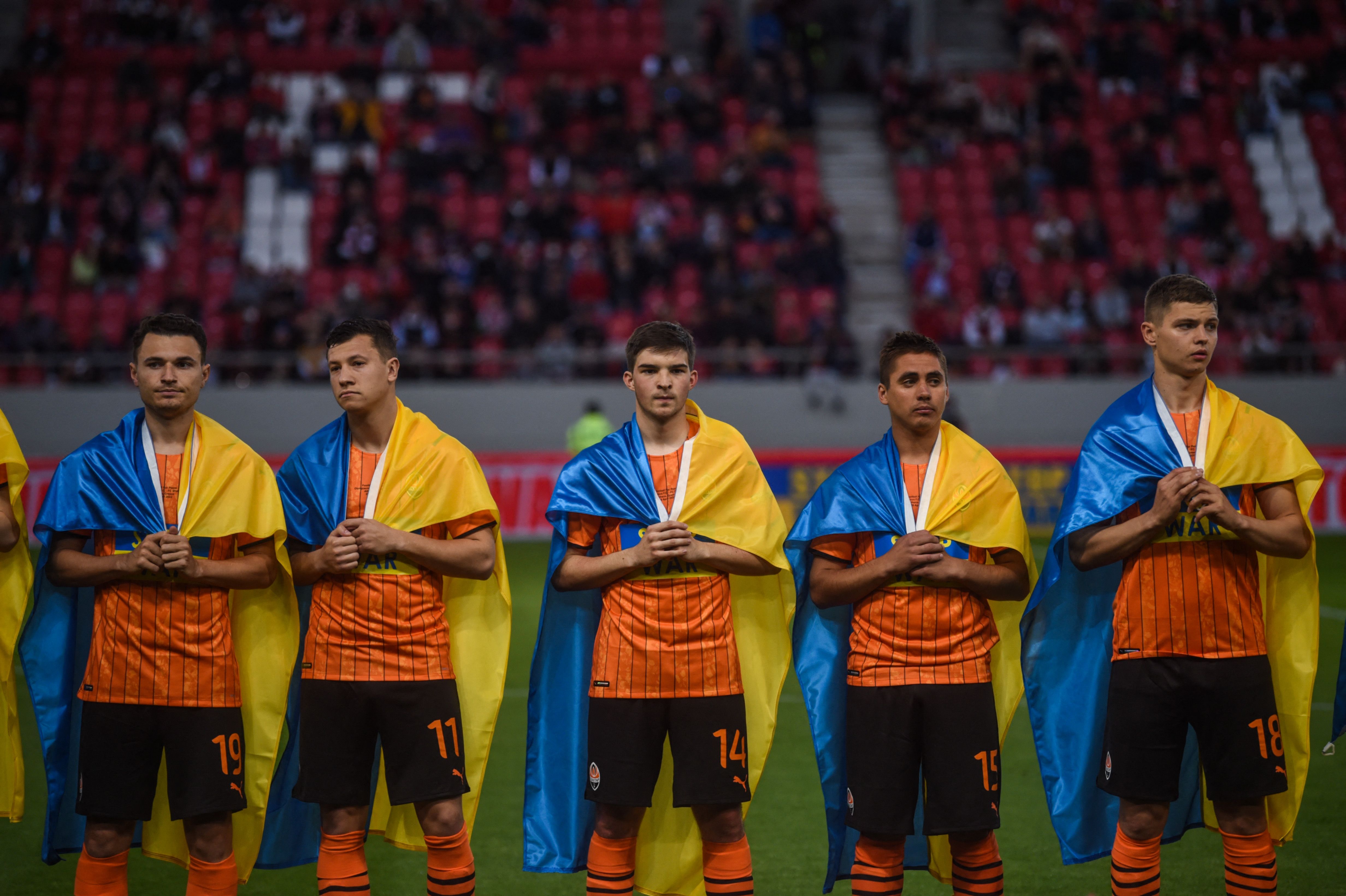 Para pemain Shakhtar Donetsk mengenakan bendera Ukraina di bahu mereka menjelang laga persahabatan melawan Olympiakos.