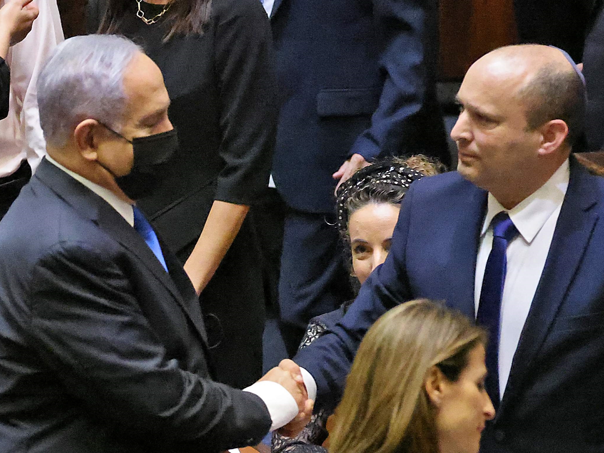 Benjamin Netanyahu berjabat tangan dengan Naftali Bennett.