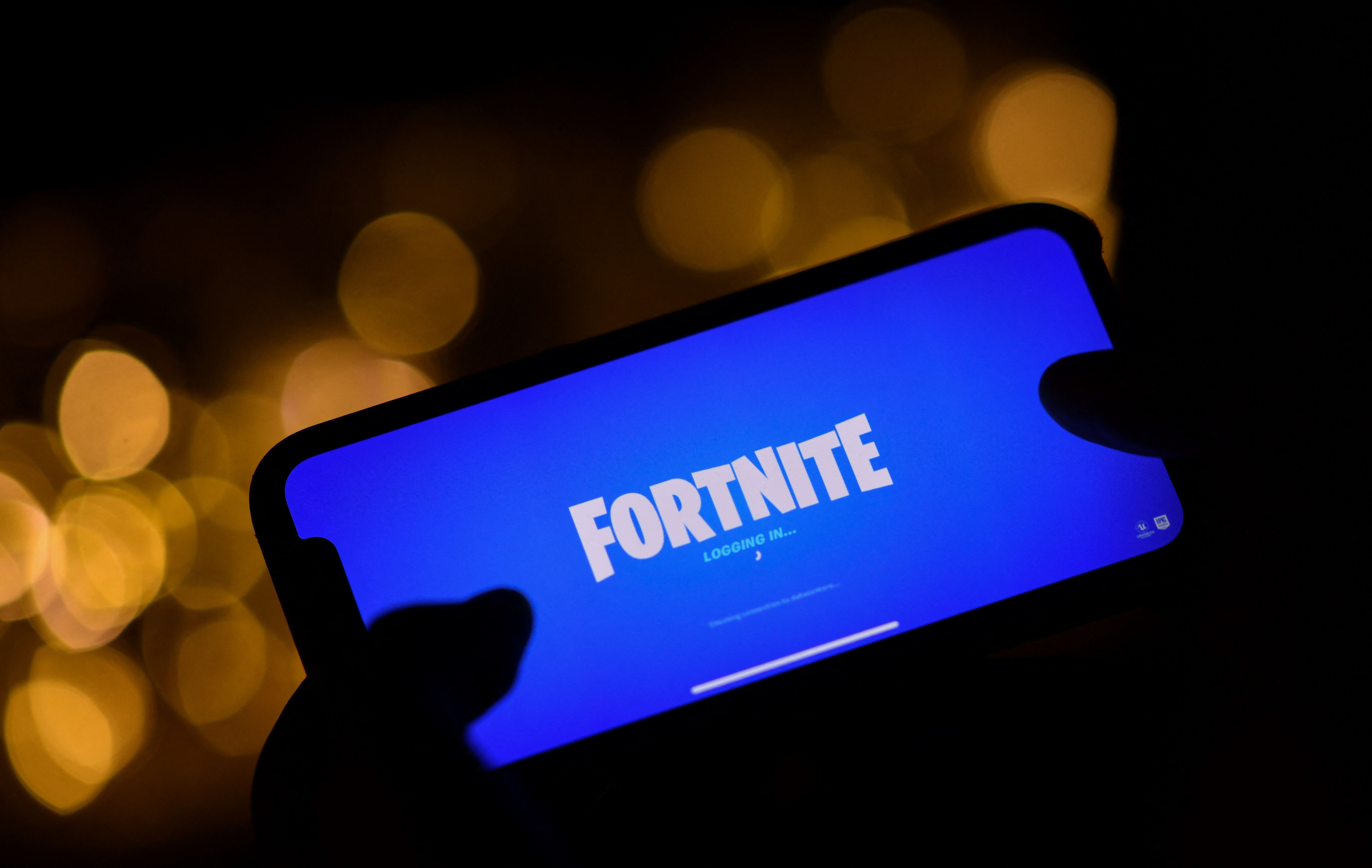 Seorang pengguna ponsel melakukan login ke gim Fortnite
