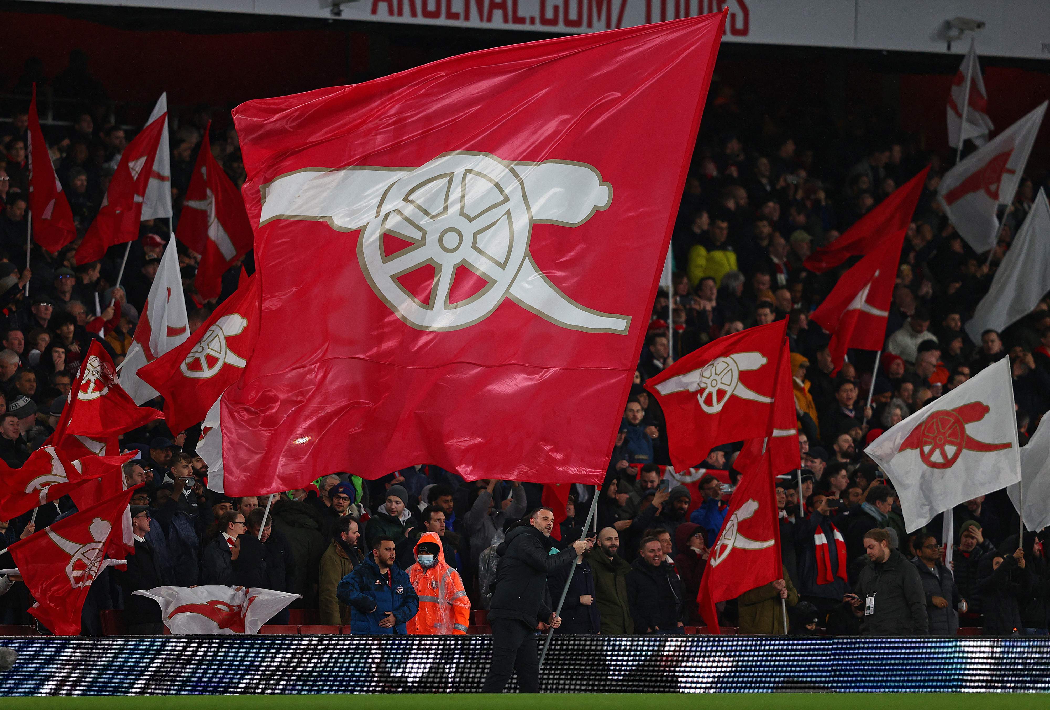 Fans mengibarkan bendera arsenal dalam pertandingan yang berlangsung di Stadion Emirates, London.