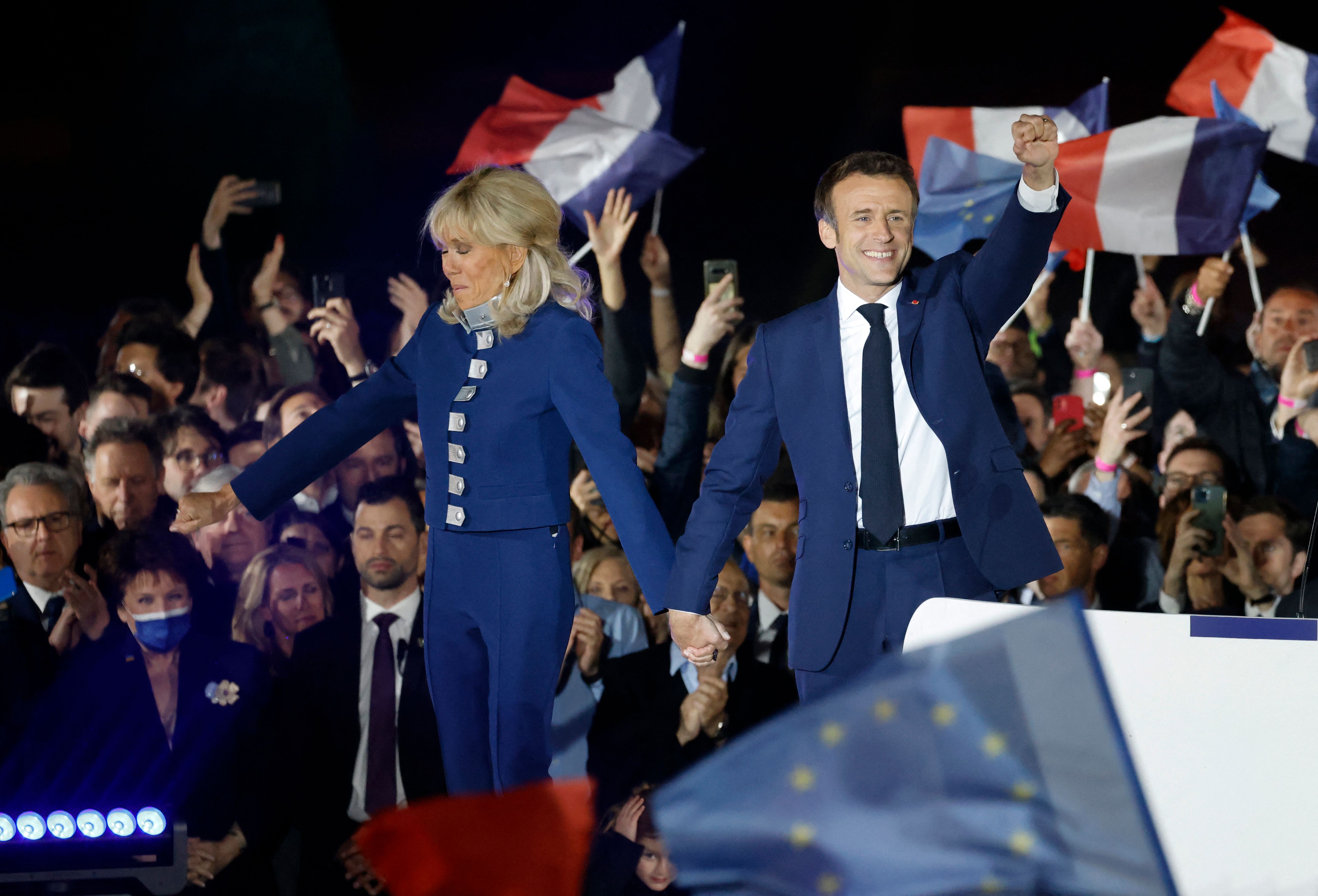 Ditemani istrinya, Presiden Emmanuel Macron melambaikan tangan kepada pendukungnya setelah kembali terpilih sebagai Presiden Prancis. 