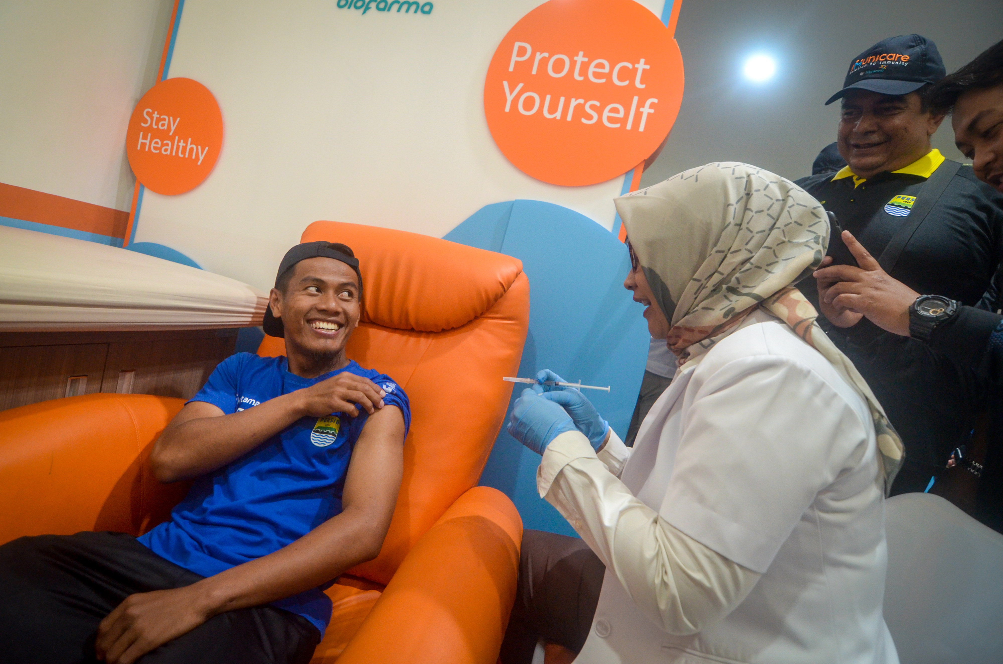 Pesepak bola Persib Bandung Ghozali Siregar (kiri) mendapat suntikan vaksin influenza di Biofarma, Bandung, Jawa Barat.