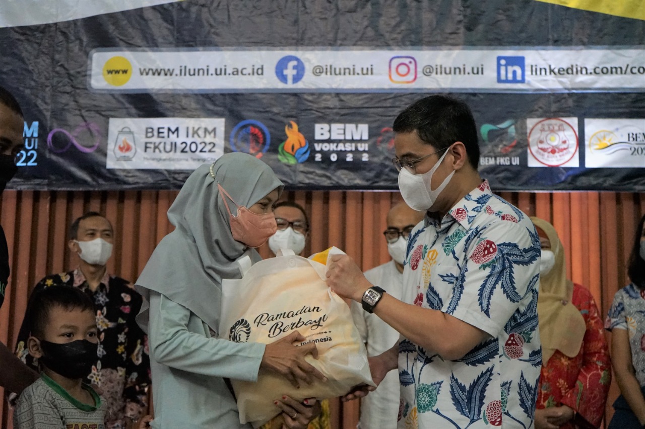 Ketua Umum Iluni Uiniversutas Indonesia Andre Rahadian saat membagikan paket sembako kepada warga