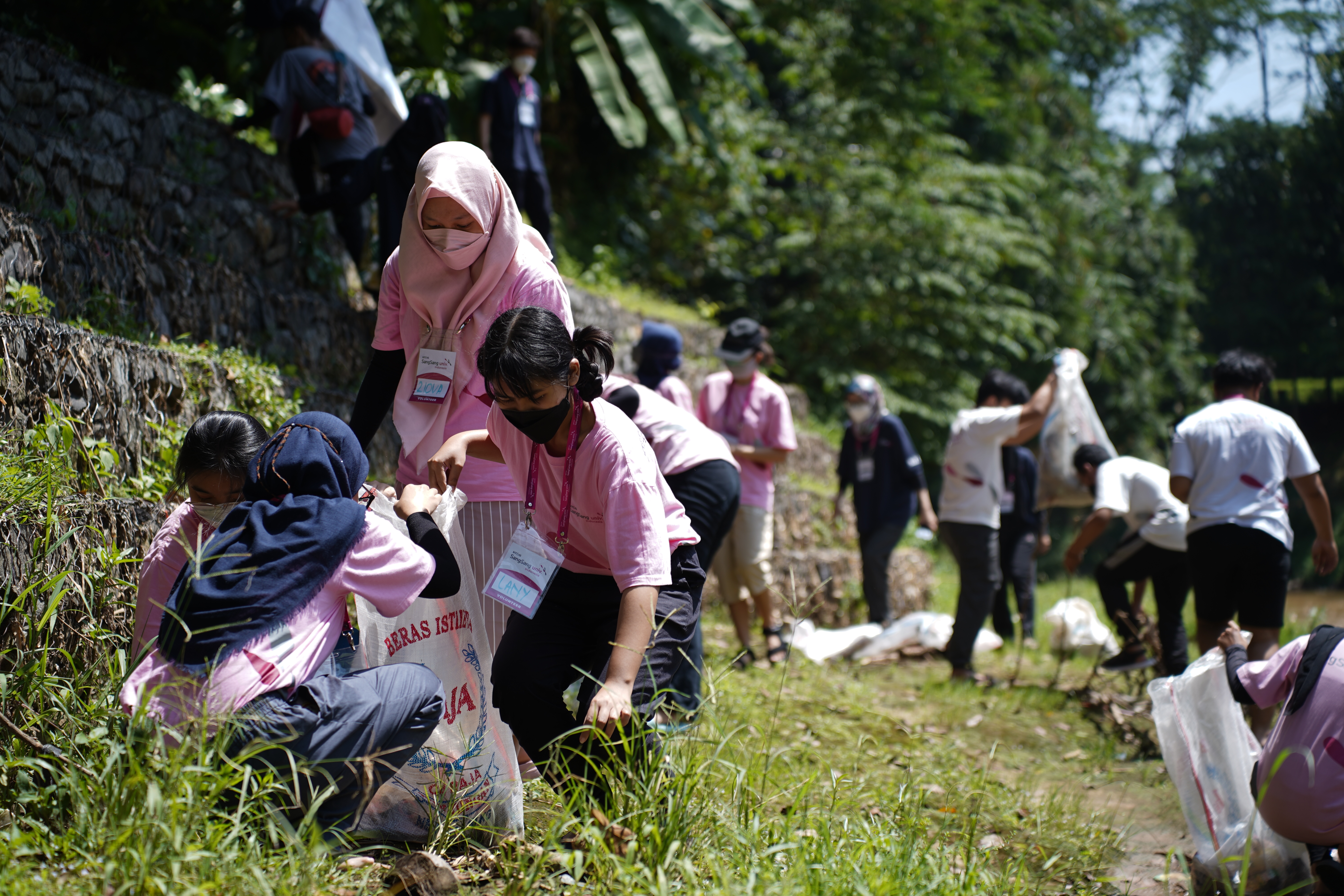 Peserta volunteer memunguti sampah anorganik di pinggiran Sungai Ciliwung.