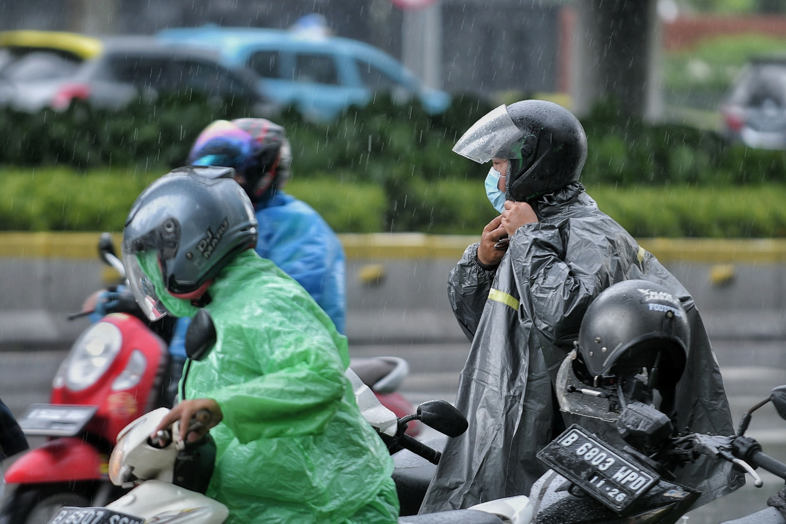 Ilustrasi. Pengendara motor sedang menggunakan jas hujan di kawasan jalan Jenderal Sudirman, Jakarta.