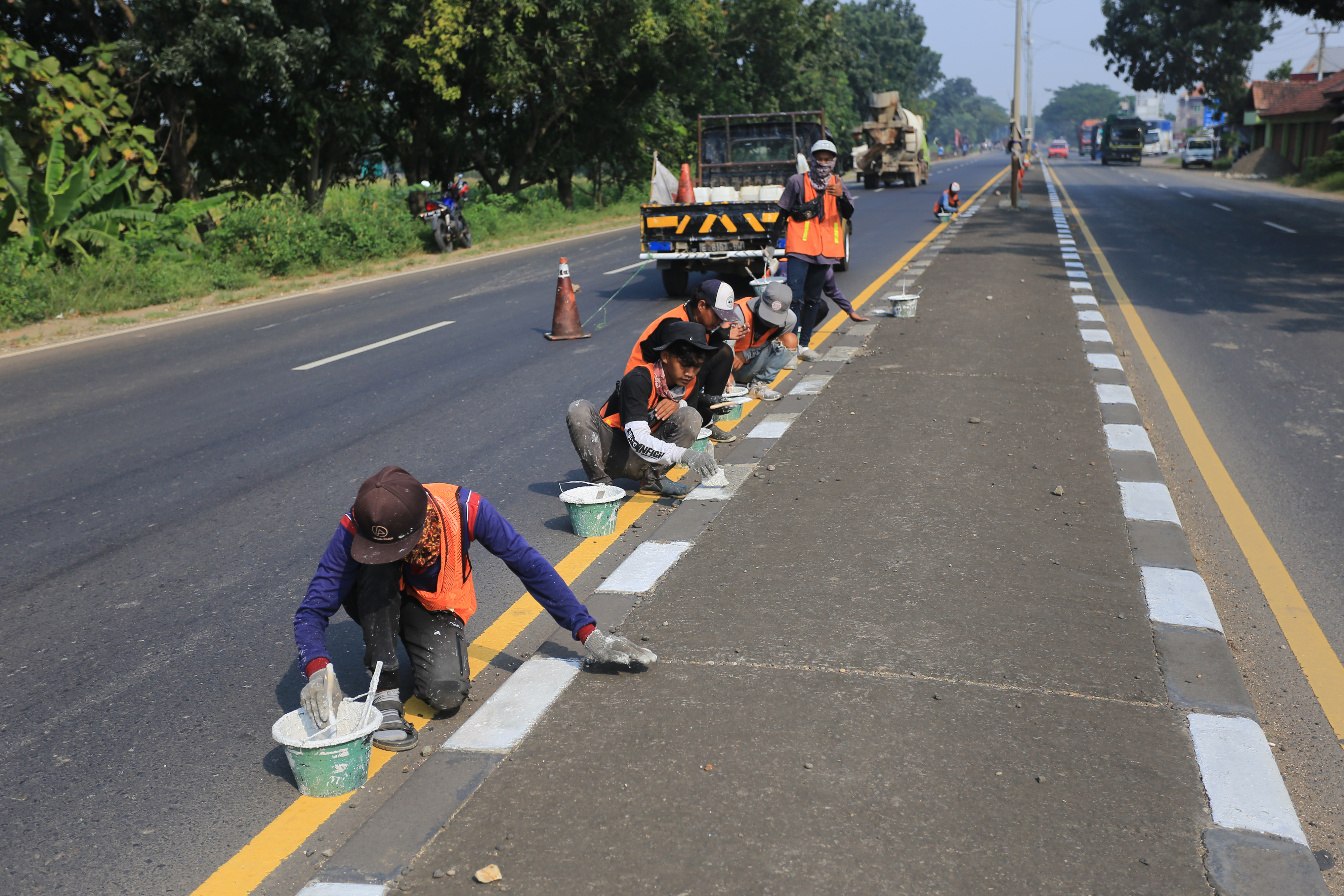 Sejumlah pekerja menyelesaikan pengecatan marka jalan di jalur pantura Widasari, Indramayu, Jawa Barat, Sabtu (16/4/2022). 