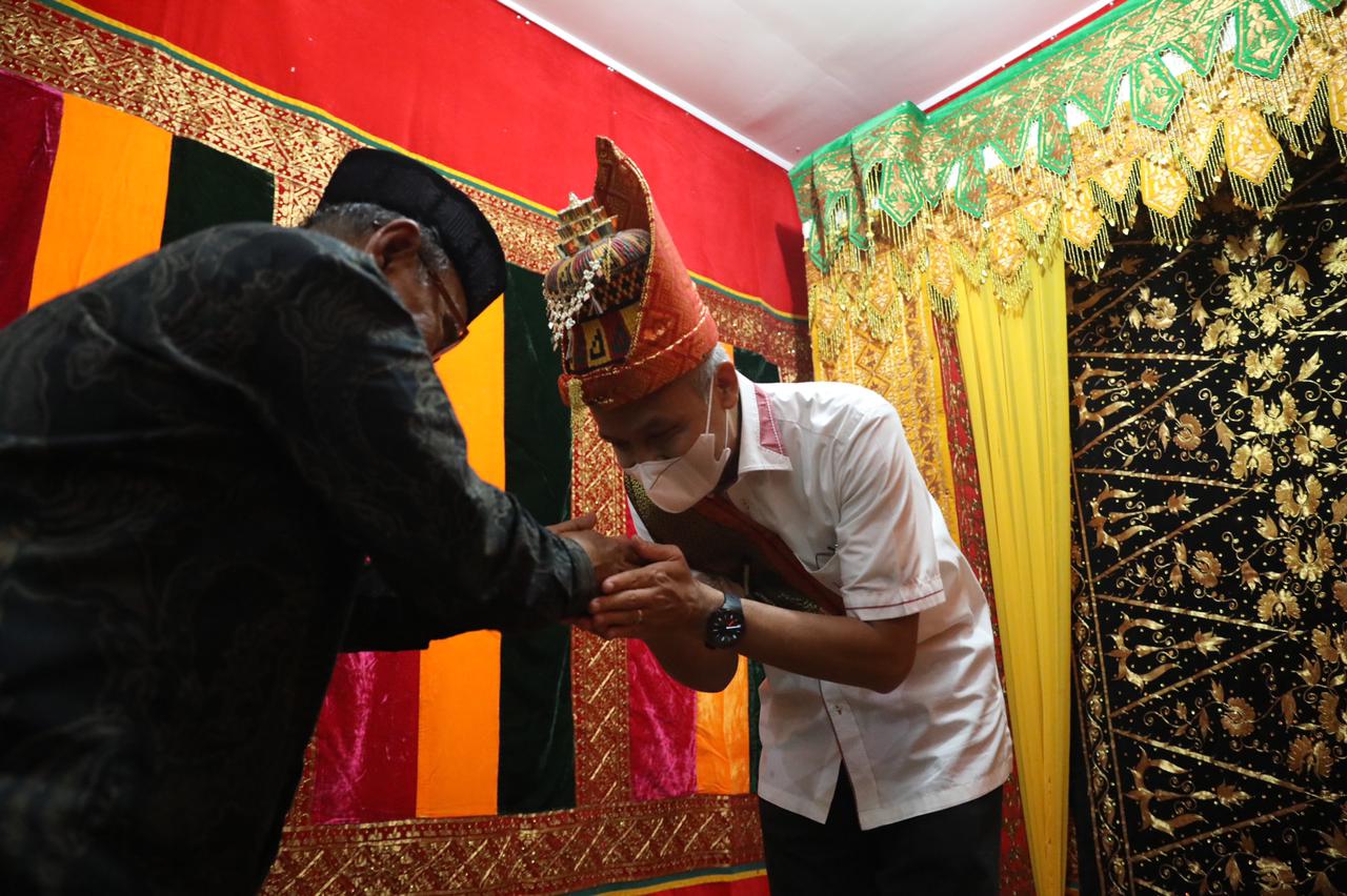 M Jalil Hasan, selaku Ketua Majelis Adat Aceh Kota Lhokseumawe, menyematkan kepiah mekeutob dan rencong kepada Ganjar, Sabtu (9/4/202