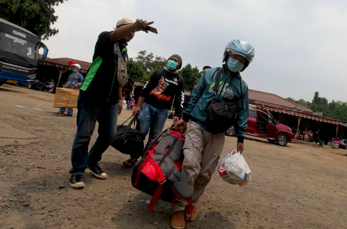 Penumpang menunggu bus keberangkatan ke beberapa daerah di Timur Jawa di terminal bayangan Lebak Bulus, Jakarta, Minggu (29/03/2020).