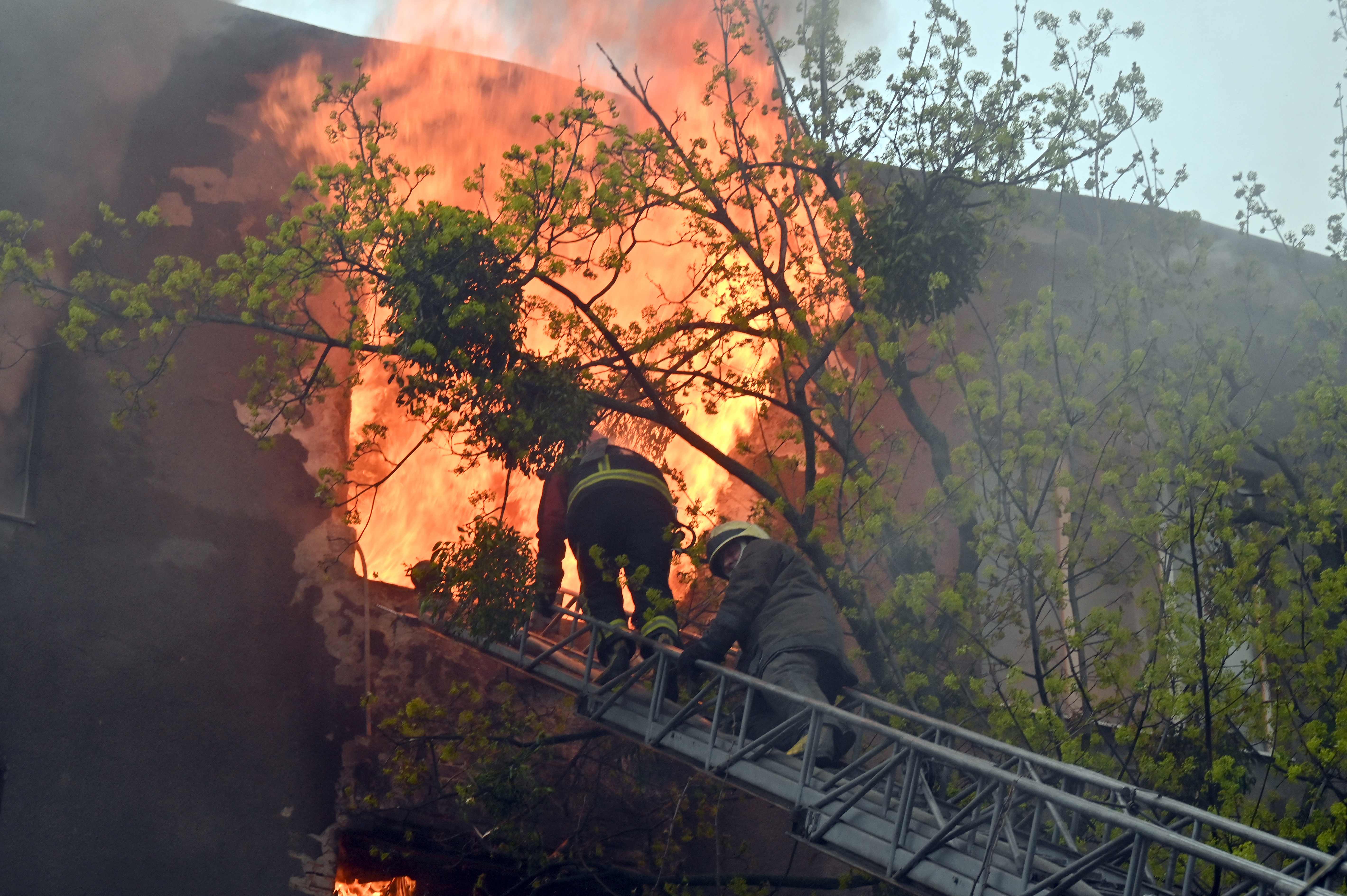 Petugas pemadam kebakaran berusaha menyelamatkan warga kota Kharkiv, Ukraina usai digempur arteri Rusia, Minggu (17/4/2022)