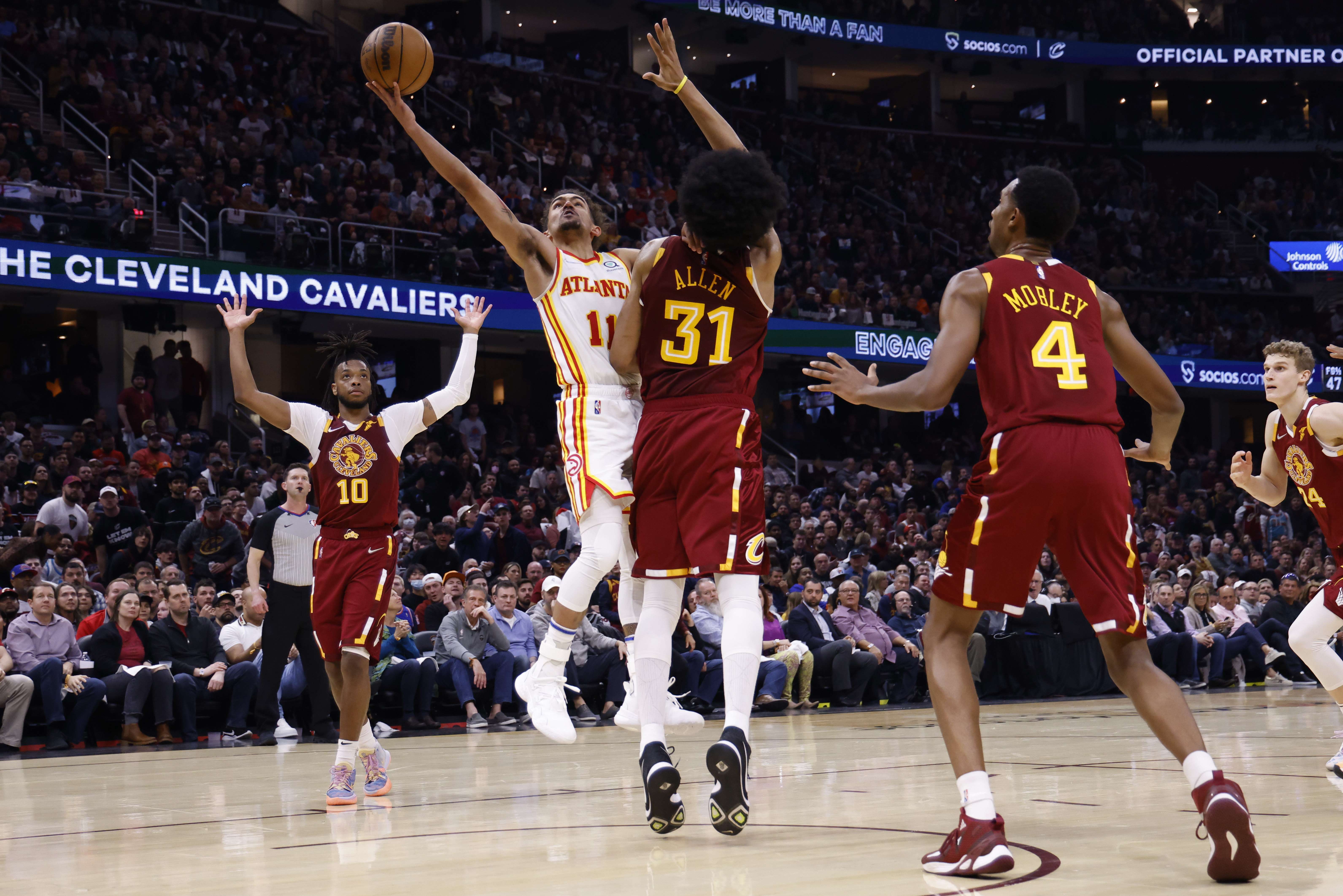 Pemain Atlanta Hawk, Trae Young (no kaus 11), siap menembakka bola dan Jarrett Allen (no kaus 31) dari Cleveland Cavalier berusaha memblok. 
