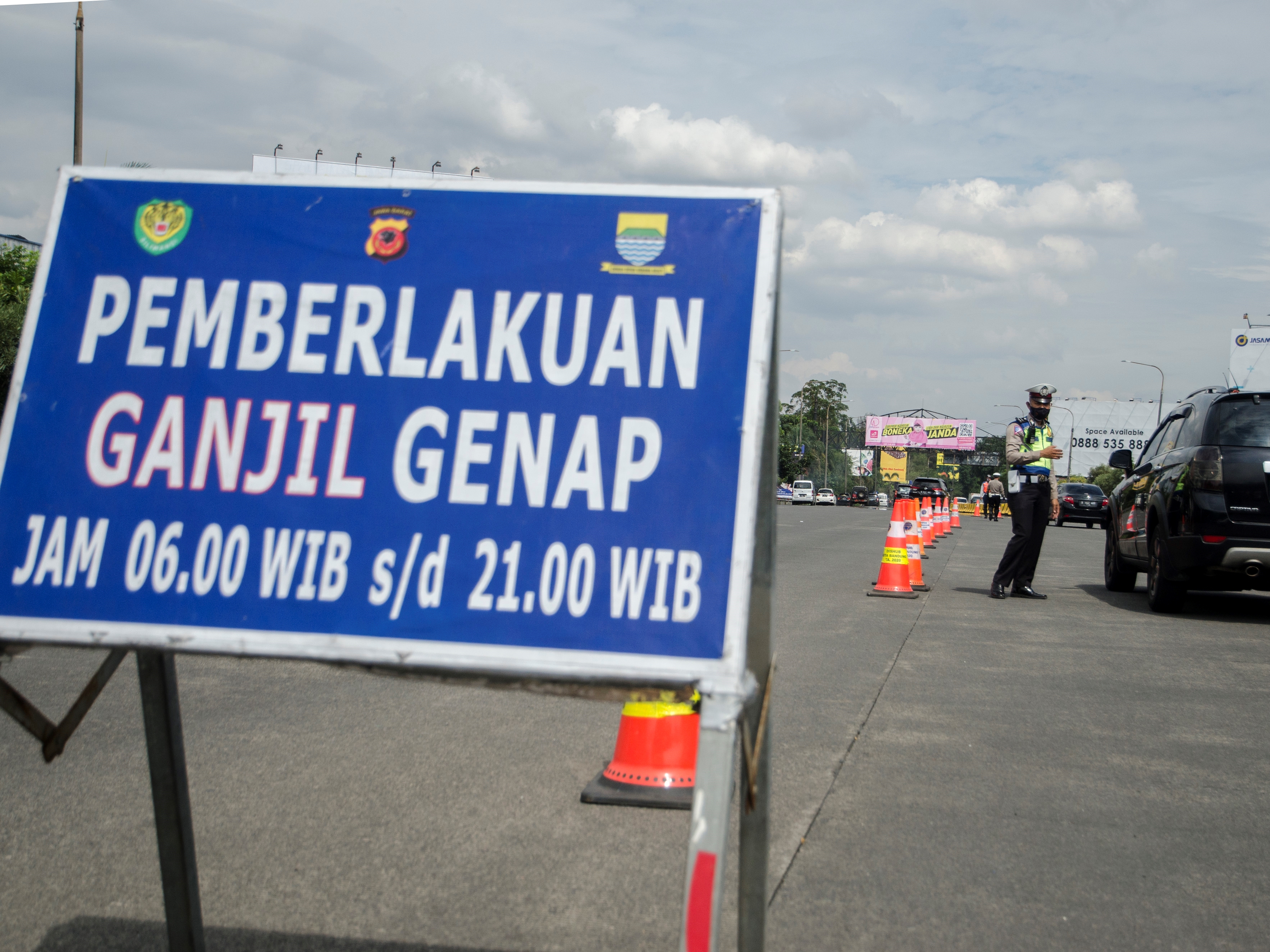 Petugas aparat gabungan melakukan penertiban penerapan ganjil-genap bagi kendaraan di Gerbang keluar Tol Pasteur, Bandung, Jumat (11/2)/