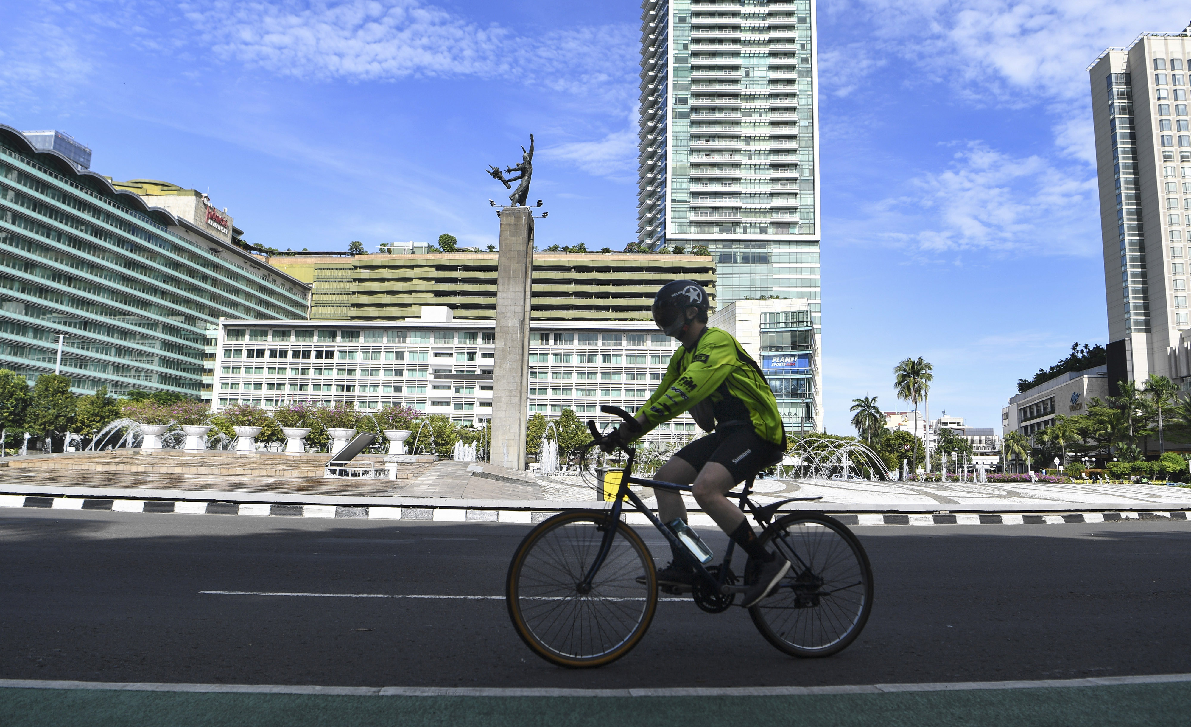 Warga bersepeda di kawasan Bundaran HI, Jakarta, Minggu (3/4), di hari pertama puasa Ramadan 1443 H.