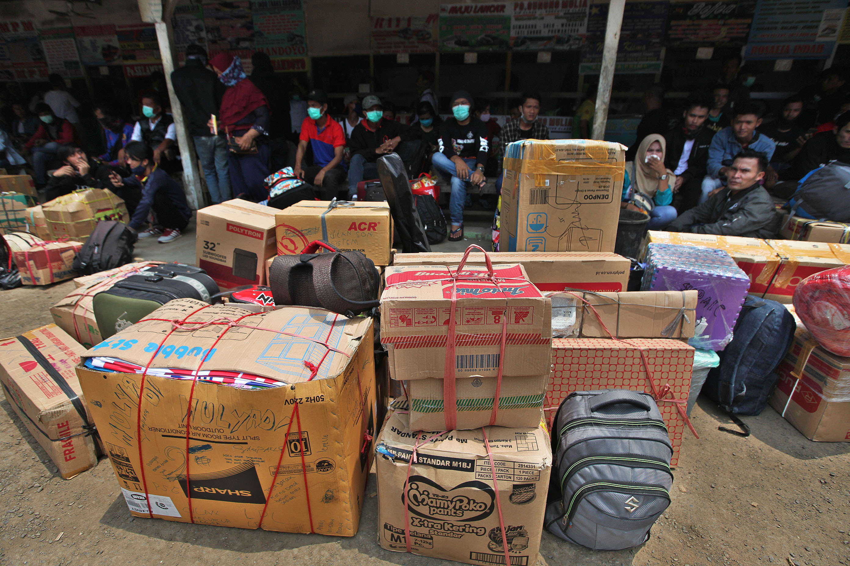 Calon penumpang menunggu bus keberangkatan ke beberapa daerah di Timur Jawa di terminal bayangan Lebak Bulus, Jakarta