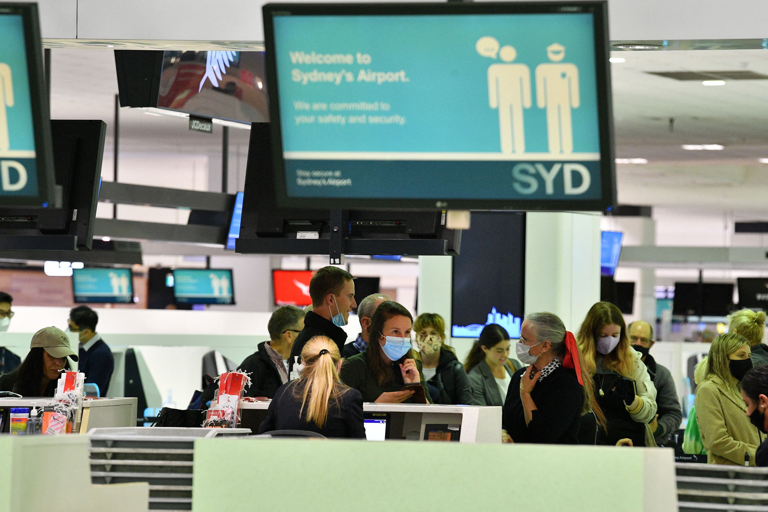 Para penumpang melalukan cek di konter untuk penerbangan tujuan Selandia Baru di Bandara Internasional Sydney, Australia.
