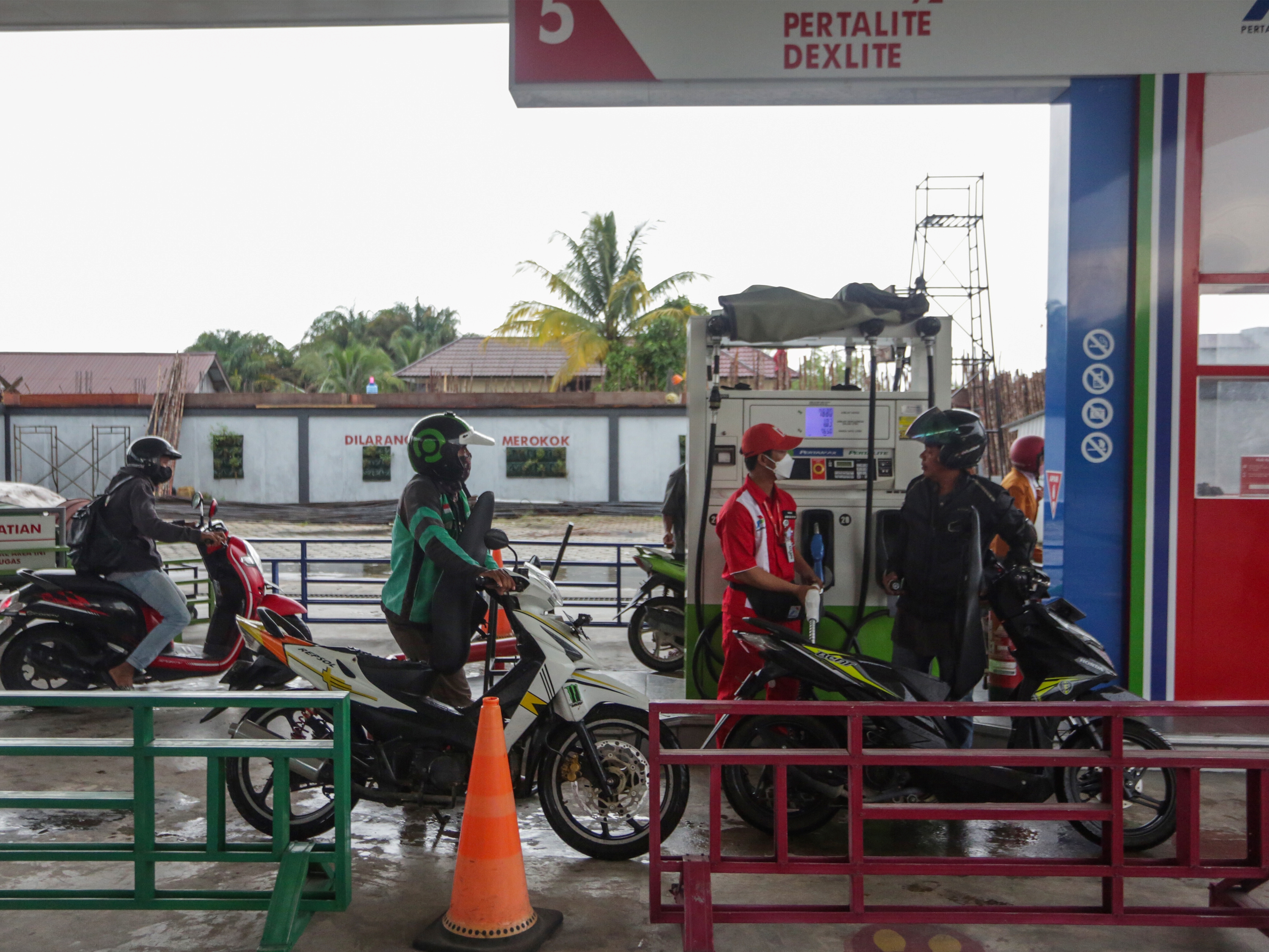 Petugas mengisi bahan bakar minyak (BBM) jenis pertalite ke sepeda motor konsumen di SPBU Yos Sudarso, Palangkaraya, Kalteng, Selasa (5/4).