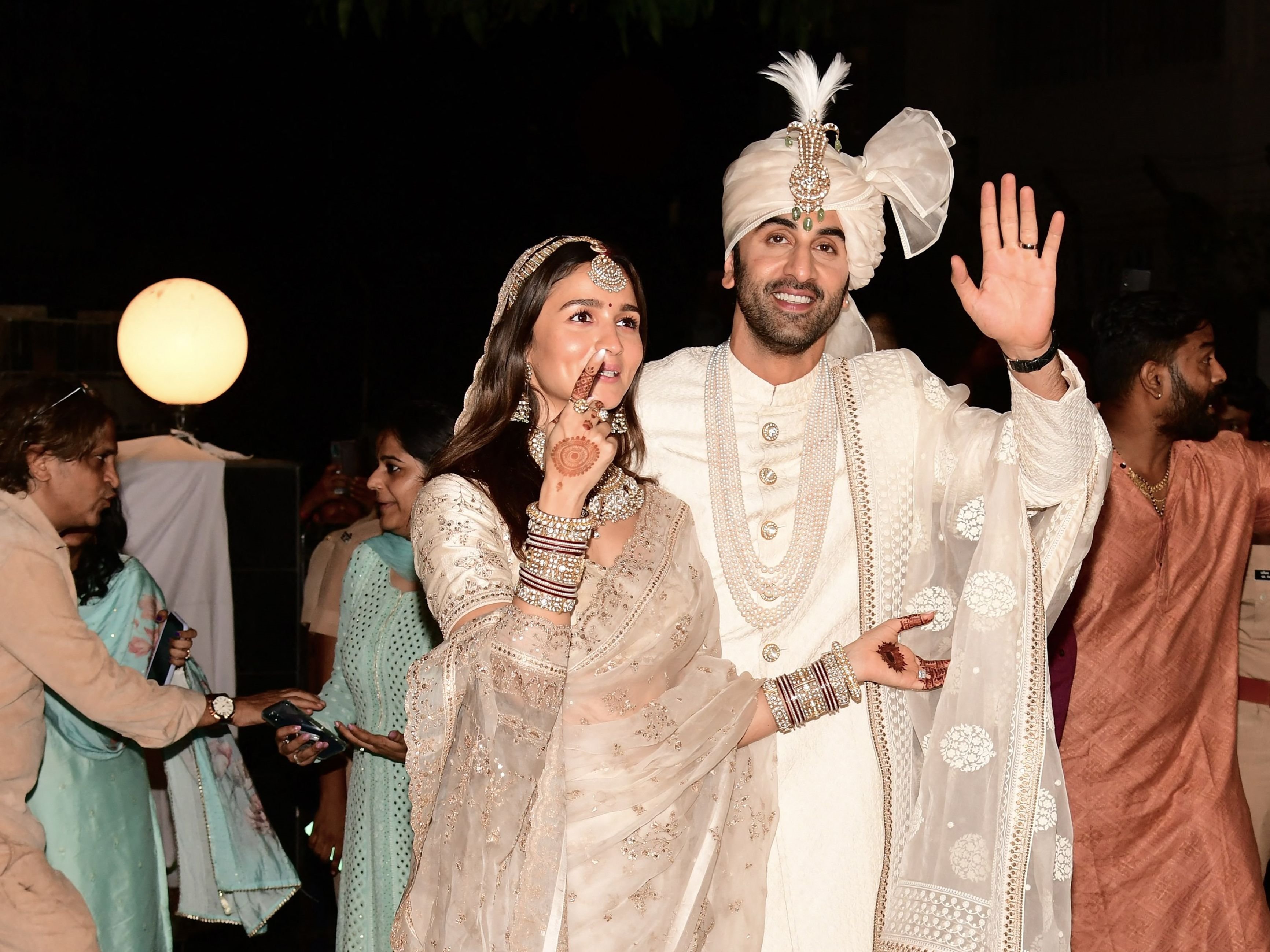 Aktor Bollywood Ranbir Kapoor (kanan) dan Alia Bhatt memberi isyarat saat upacara pernikahan mereka di Mumbai pada 14 April 2022.