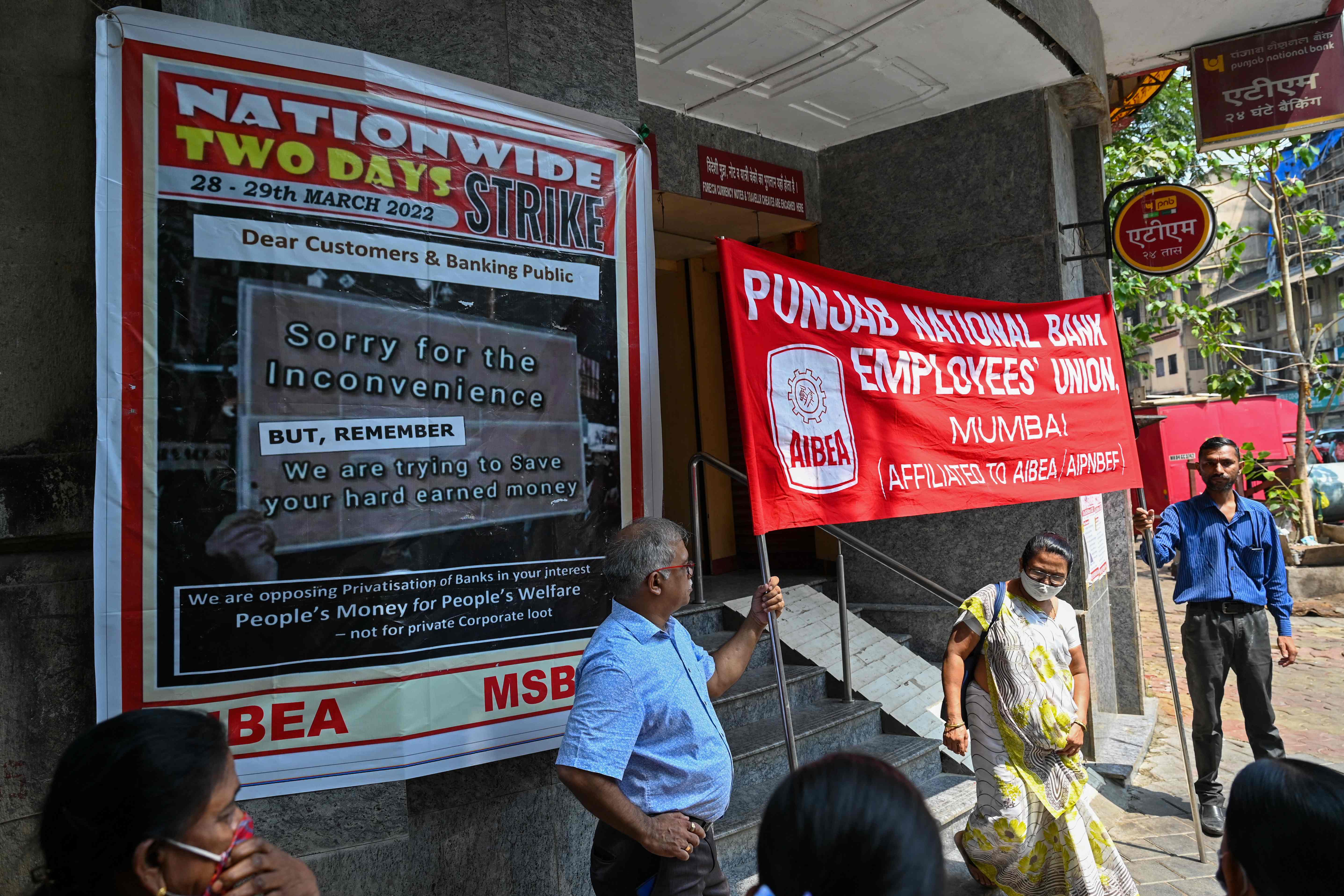 Pegawai Bank Punjab National membawa poster saat protes terhadap kebijakan perbankan dari pemerintah India di Mumbai, India.  