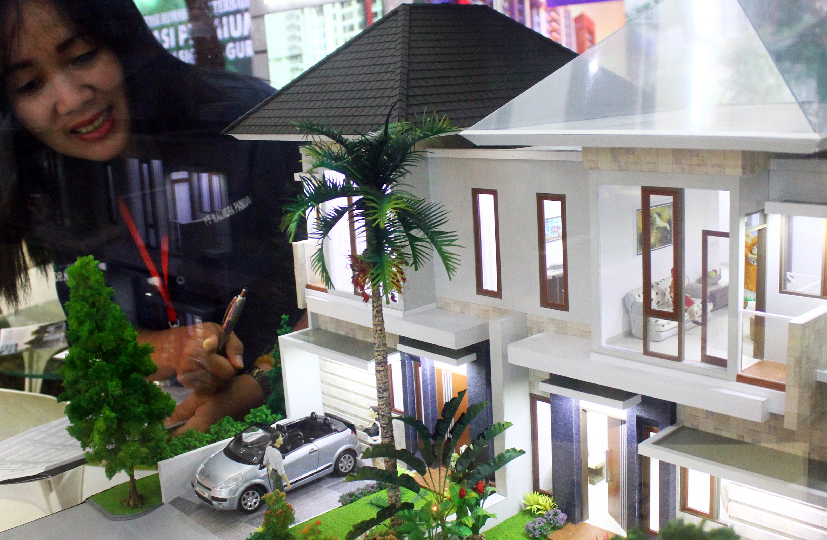Tenaga pemasar menunjukkan maket properti.