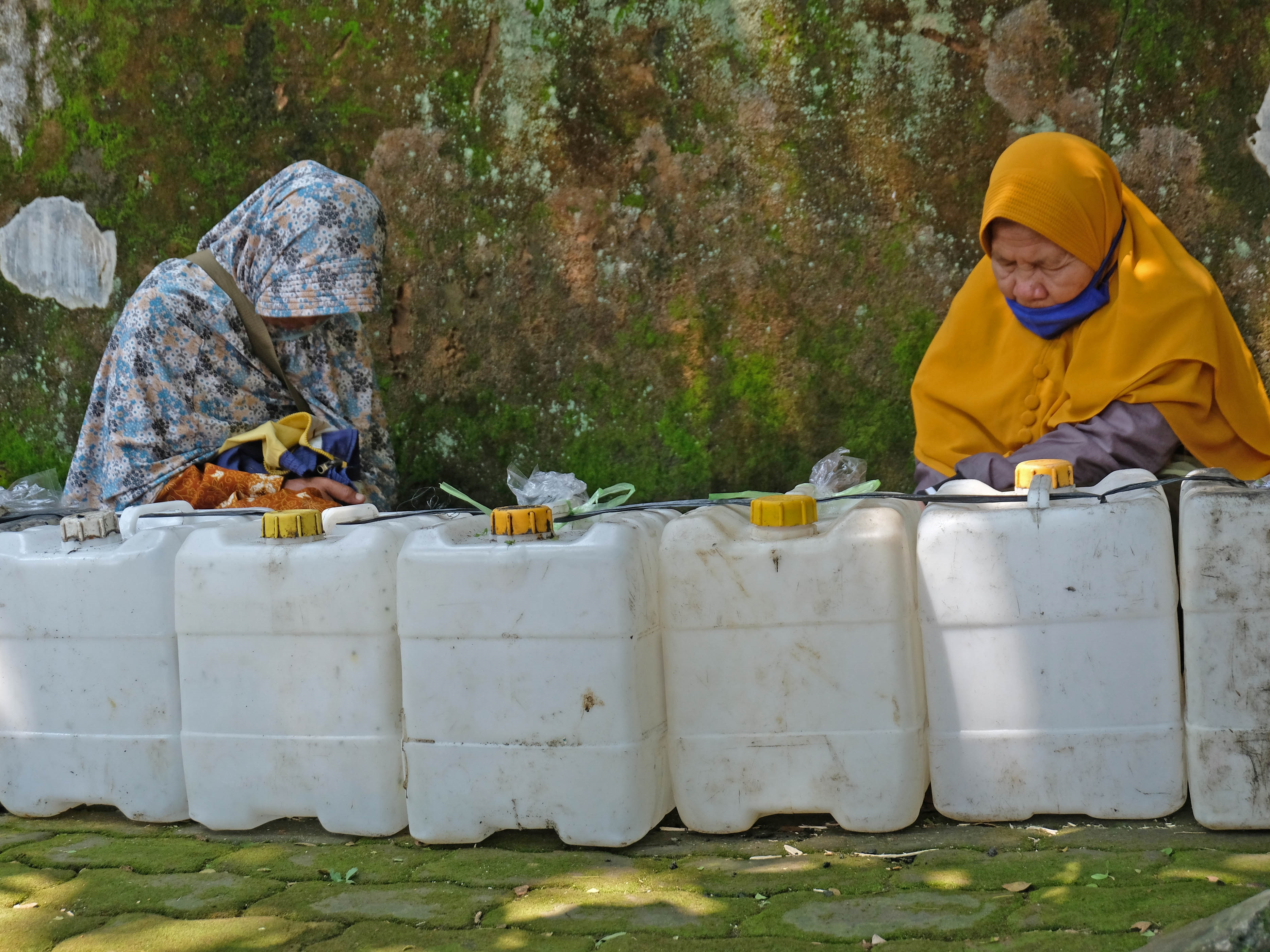Warga tertidur saat antre membeli minyak goreng curah di distributor minyak goreng di Kota Temanggung, Jawa Tengah, Senin (11/4/2022).